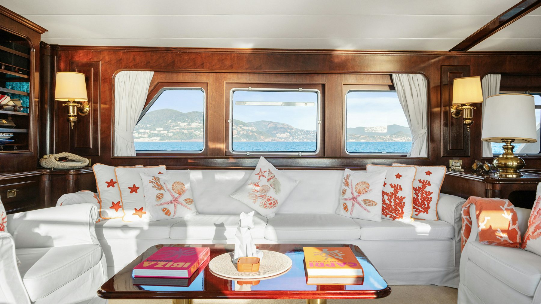 a living room with a large white couch and a large window aboard AMMIRAGLIO Yacht for Sale