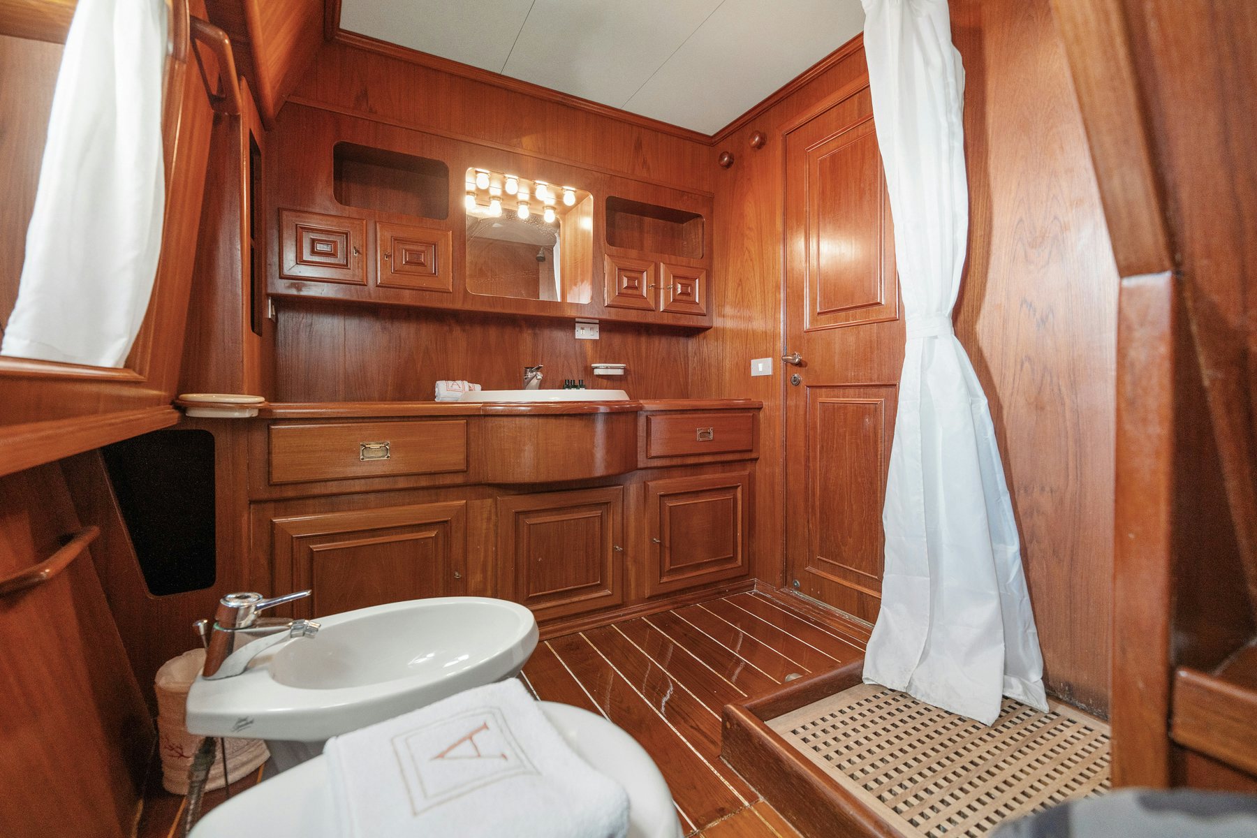 a bathroom with a sink and a shower curtain aboard AMMIRAGLIO Yacht for Sale