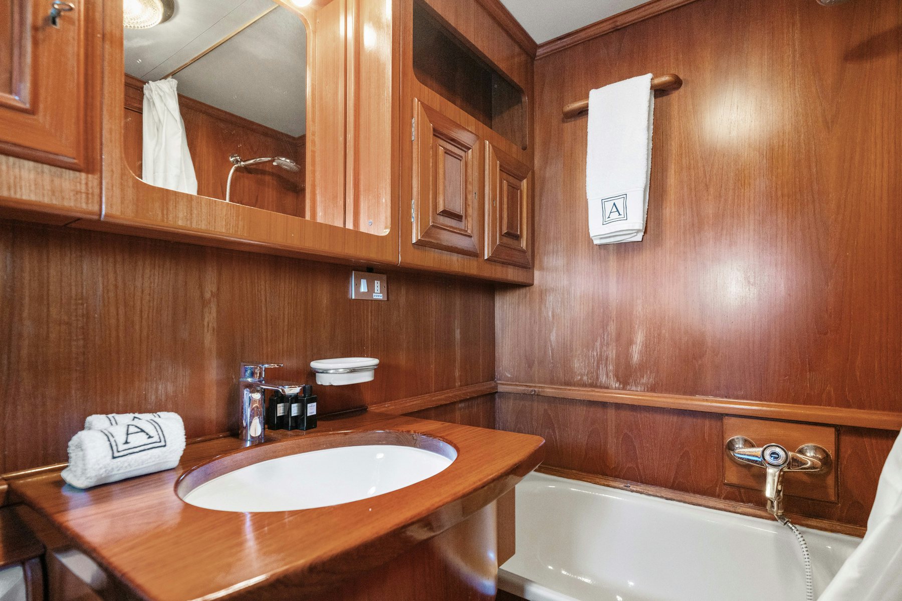 a bathroom with wooden cabinets aboard AMMIRAGLIO Yacht for Sale
