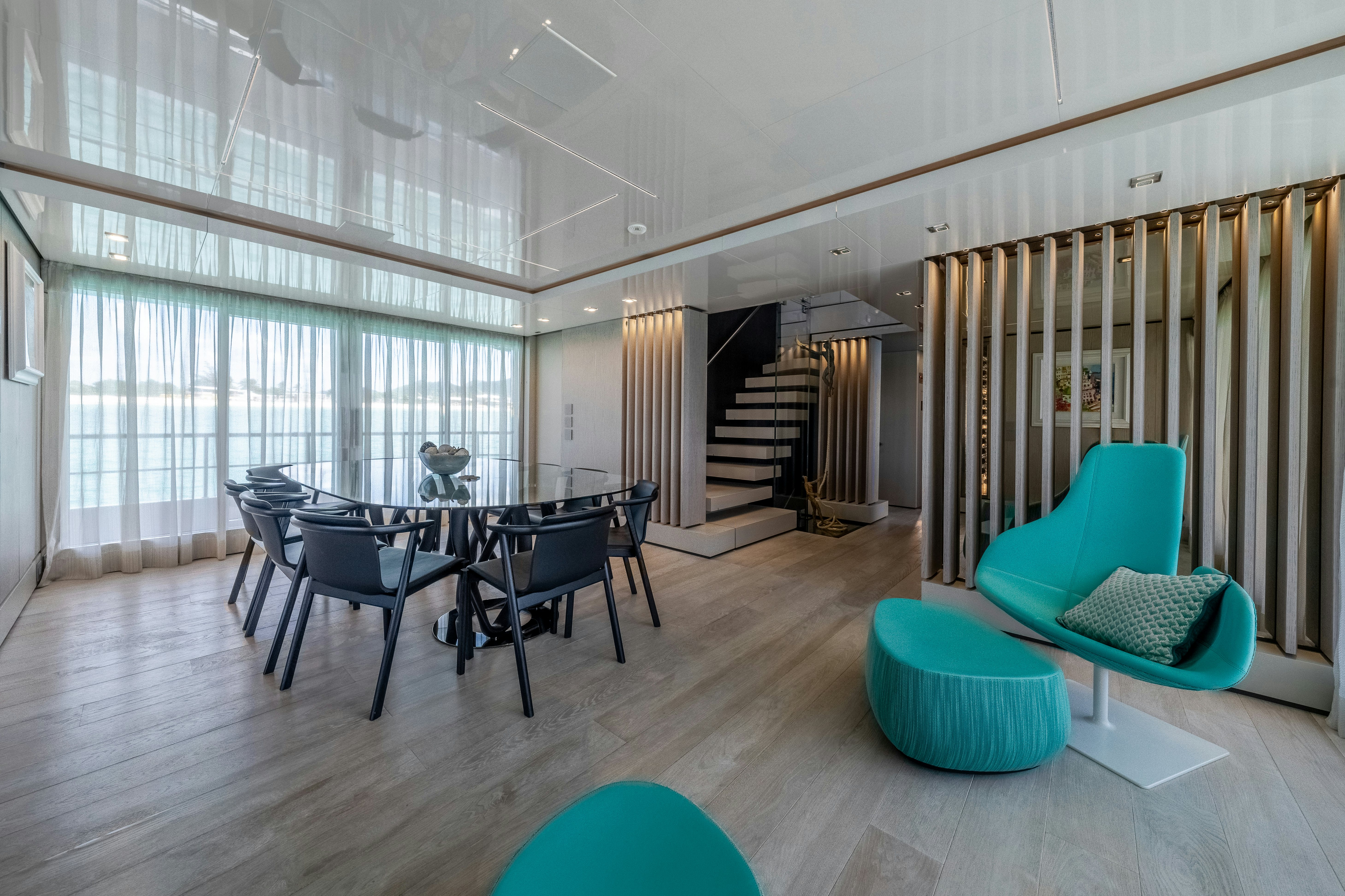 a room with a table chairs and a staircase aboard EMOCEAN Yacht for Sale