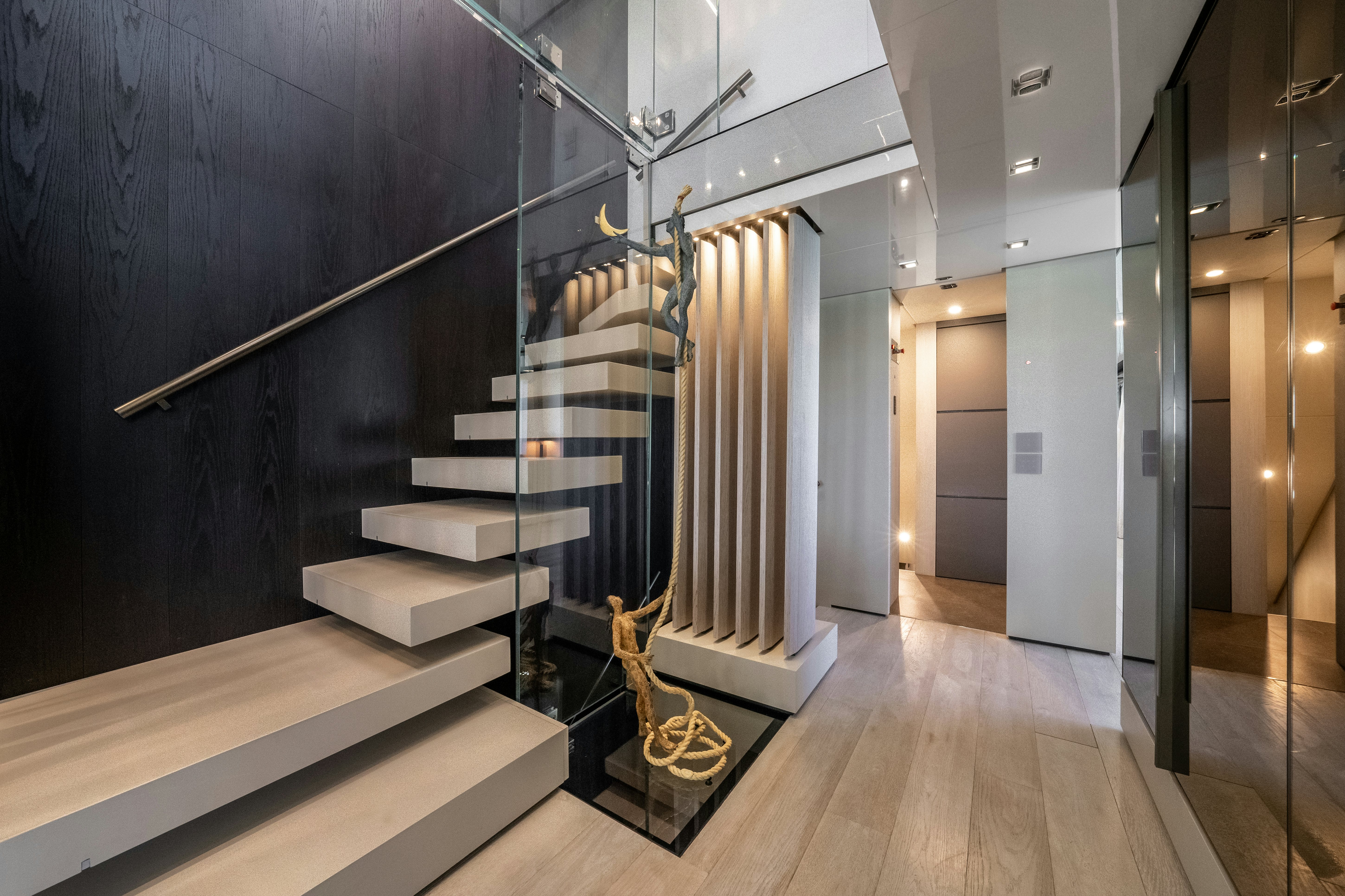 a hallway with a staircase and a statue aboard EMOCEAN Yacht for Sale