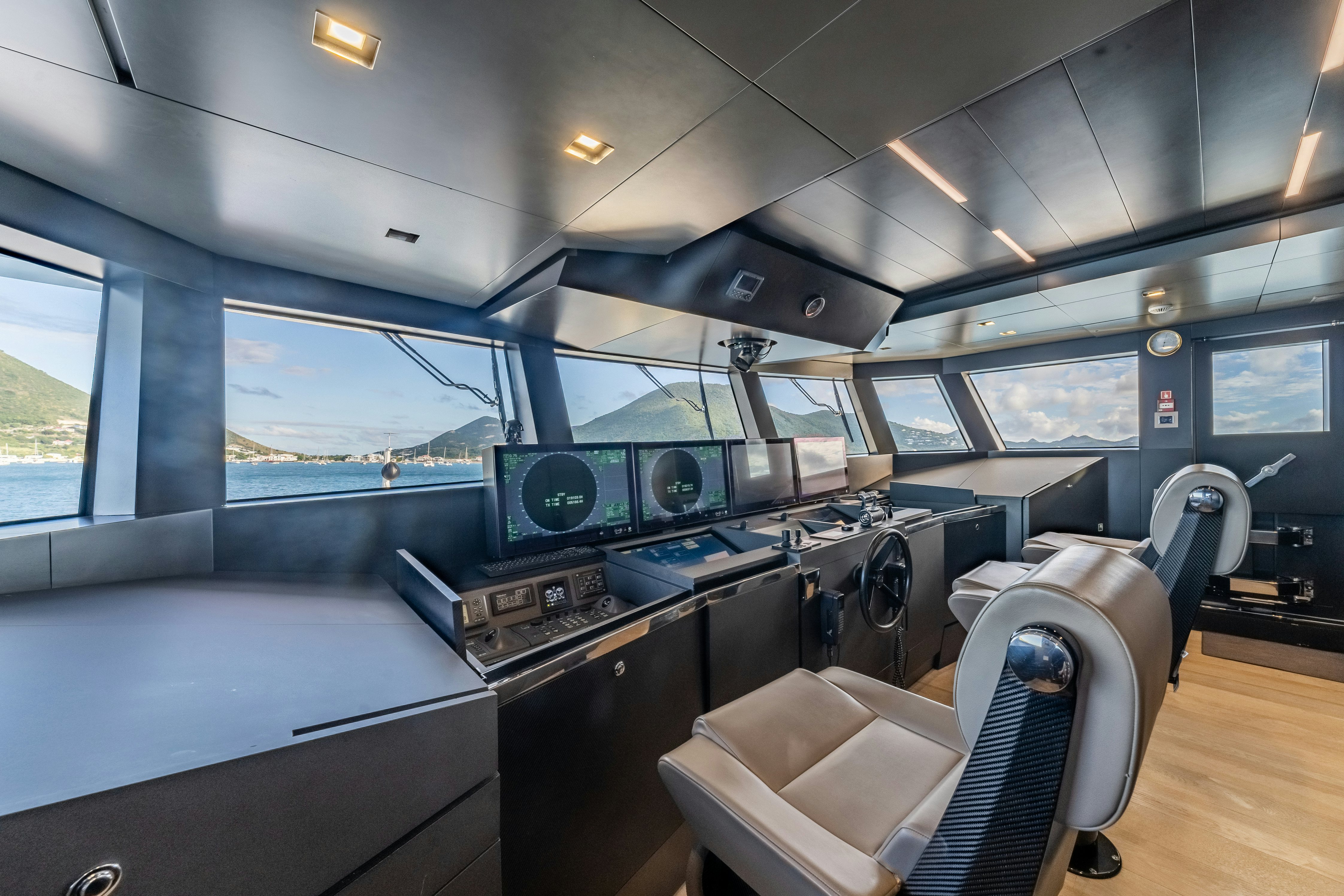 a room with a large window and a table with chairs aboard EMOCEAN Yacht for Sale