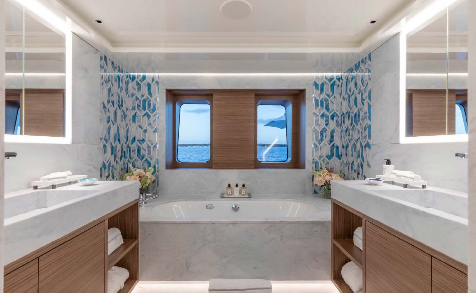 a bathroom with a tub sink and cabinets aboard MOONSTONE Yacht for Sale