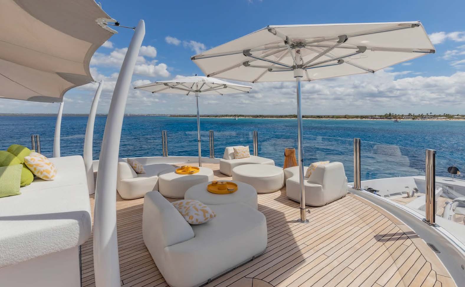 a large white umbrella over a white table on a deck overlooking the ocean aboard MOONSTONE Yacht for Sale