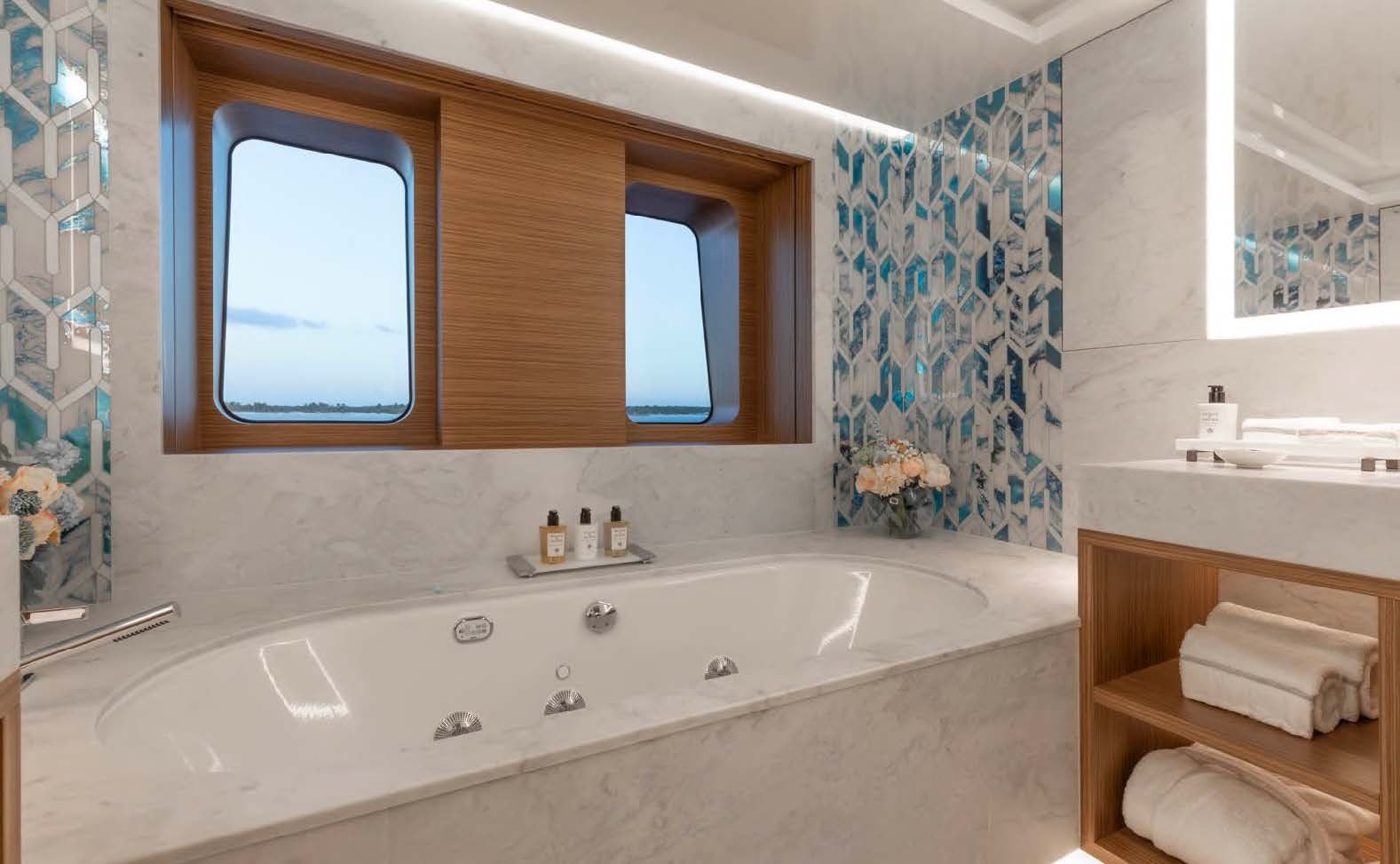 a bathroom with a tub and a mirror aboard MOONSTONE Yacht for Sale