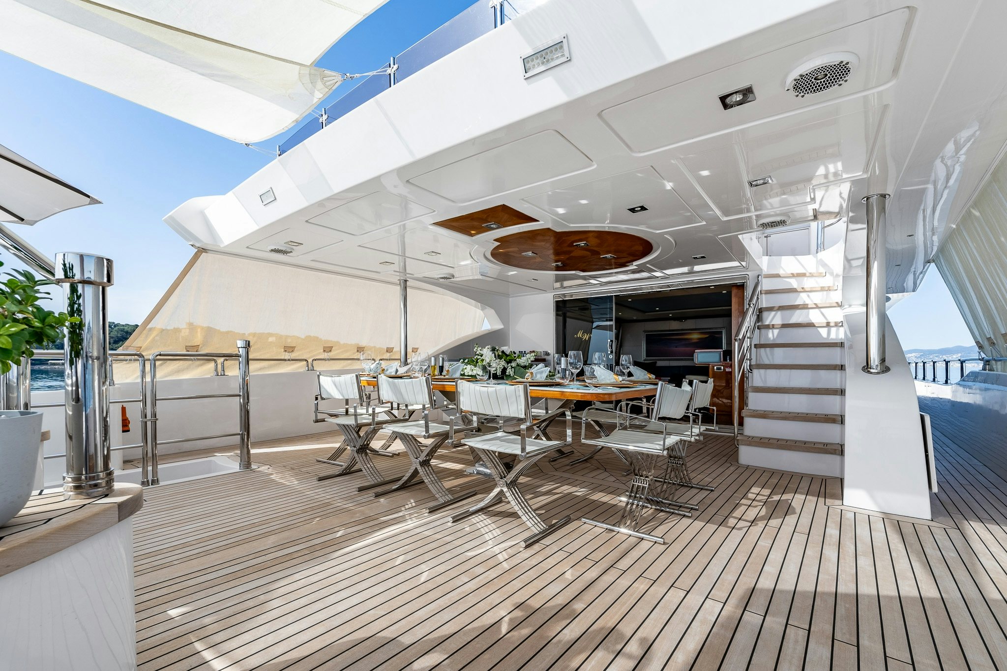 a room with a staircase and tables aboard GRAND CRU Yacht for Sale