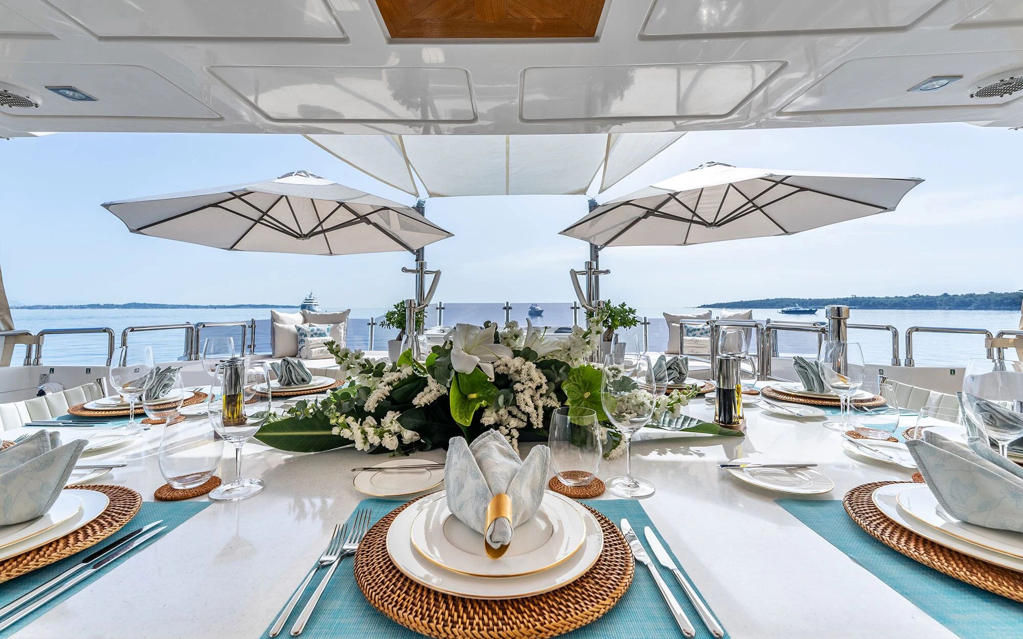 a table with plates and glasses aboard GRAND CRU Yacht for Charter