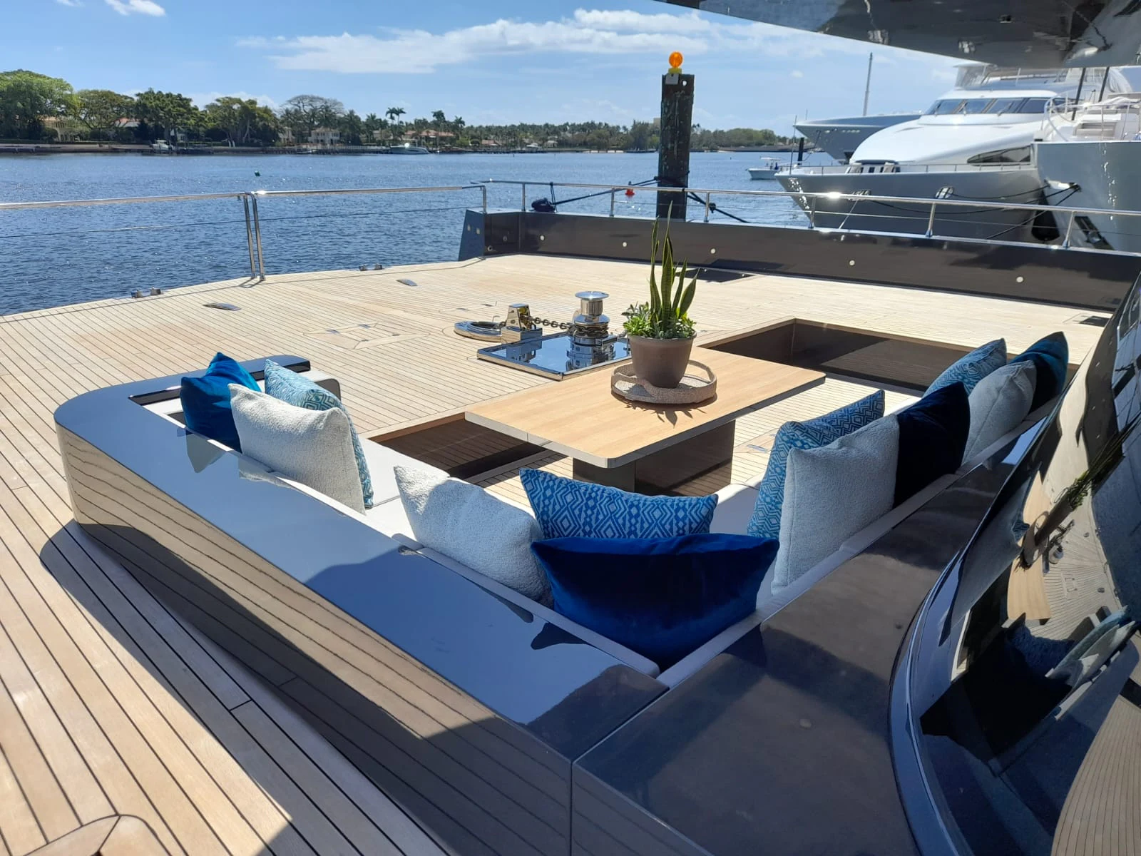 a deck with a table and chairs on it by a body of water aboard FLAGSHIP Yacht for Sale
