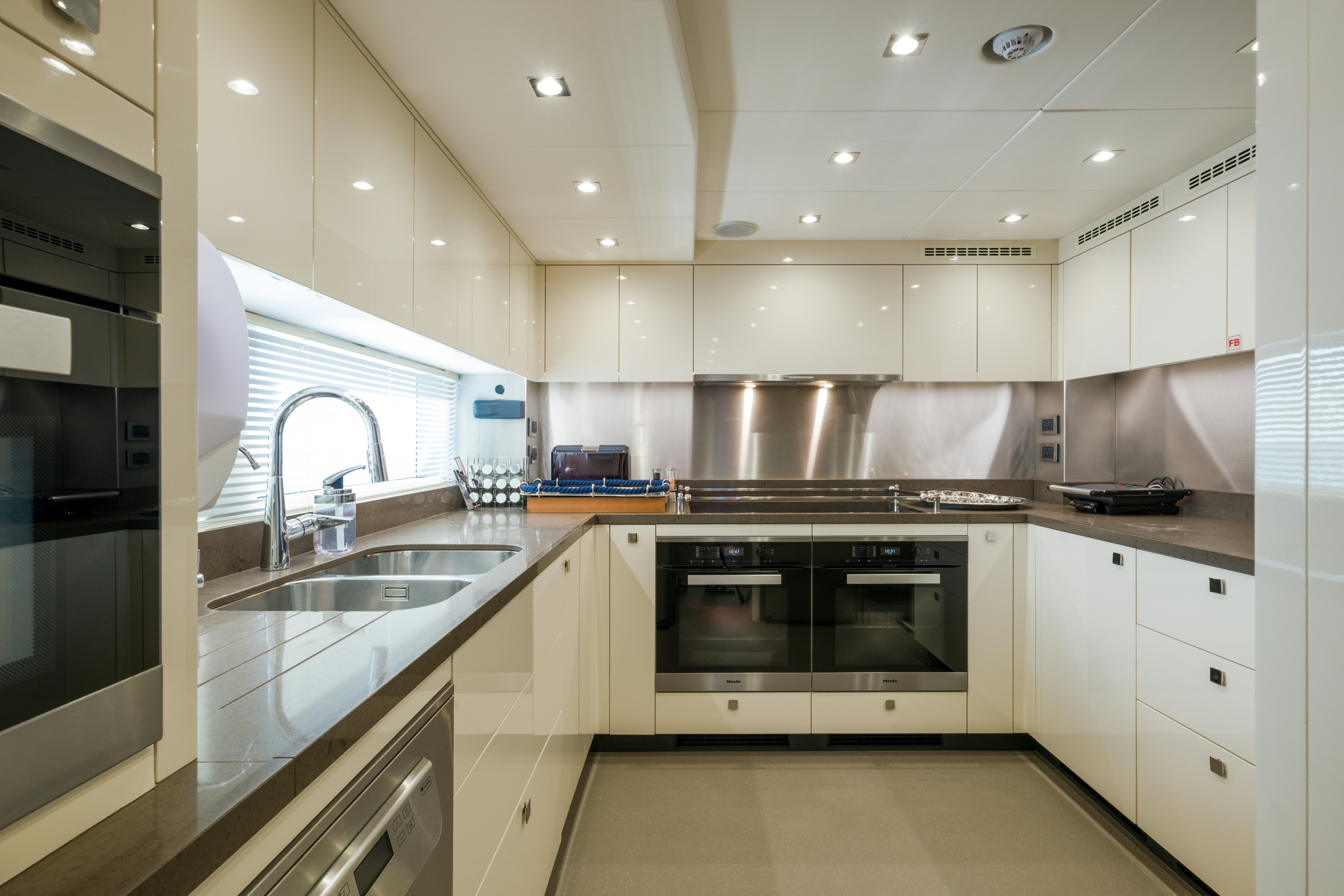a kitchen with white cabinets aboard MERCY OCEANS Yacht for Sale