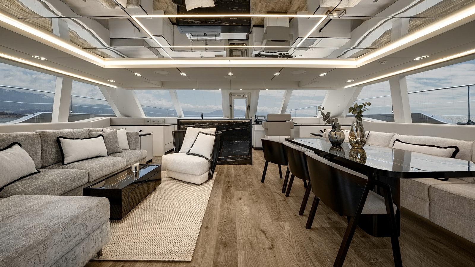 a room with a couch and a table and a large window aboard AMILEO Yacht for Charter