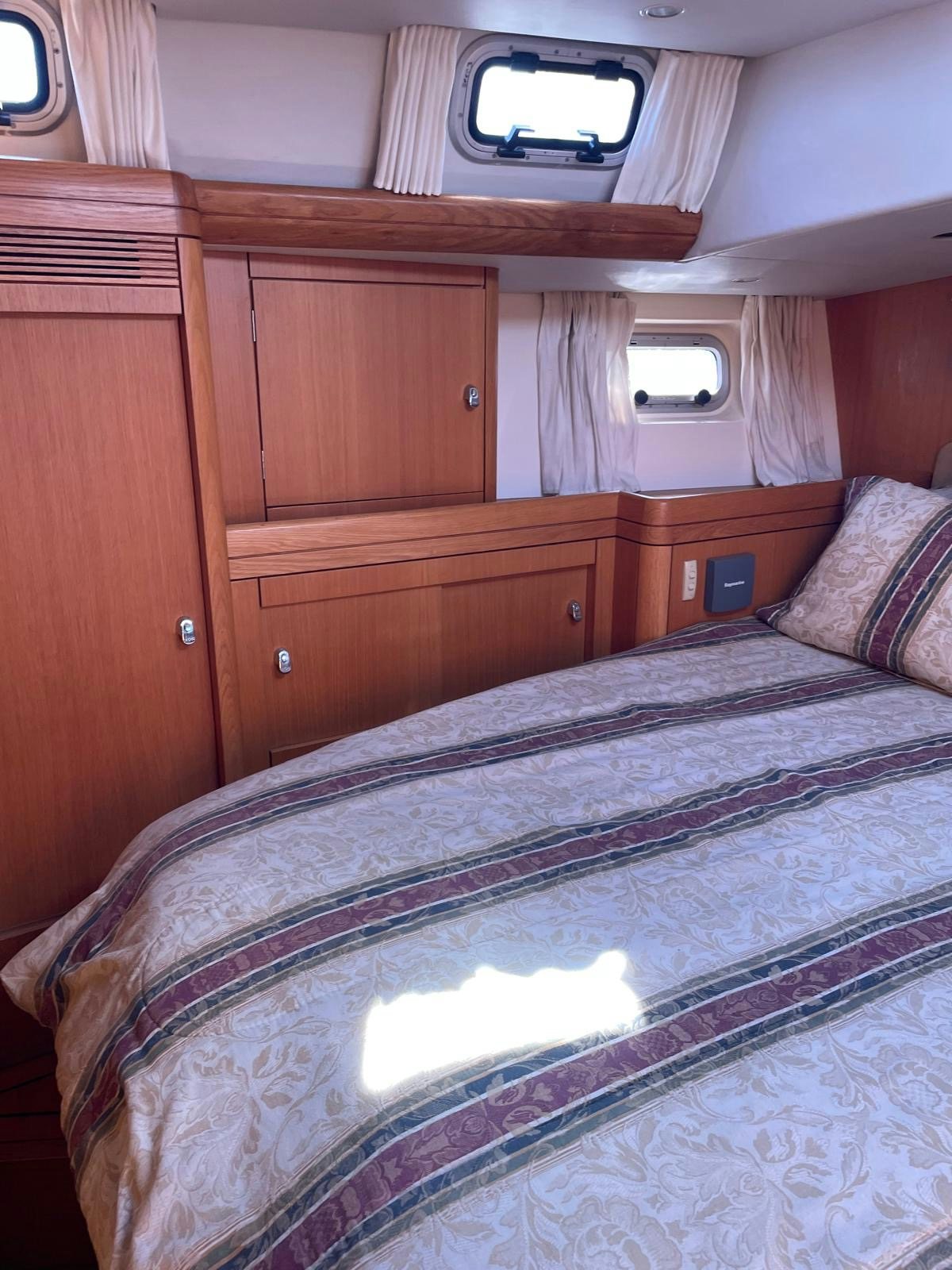 a bed with a wooden headboard aboard DREAM AGAIN II Yacht for Sale