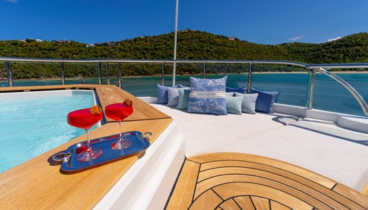 a table with chairs and a pool aboard SCOTT FREE Yacht for Charter