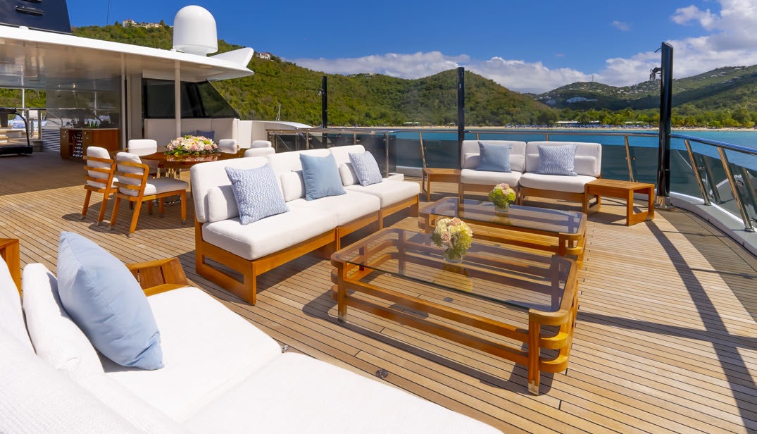 a deck with a table and chairs aboard SCOTT FREE Yacht for Charter