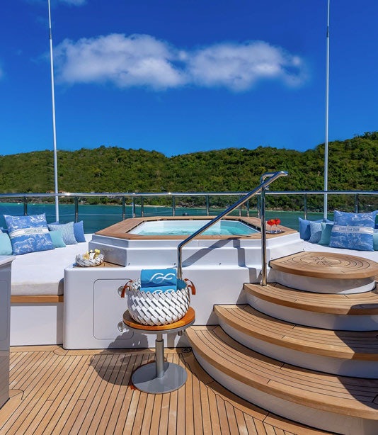 a deck with a table and chairs aboard SCOTT FREE Yacht for Charter