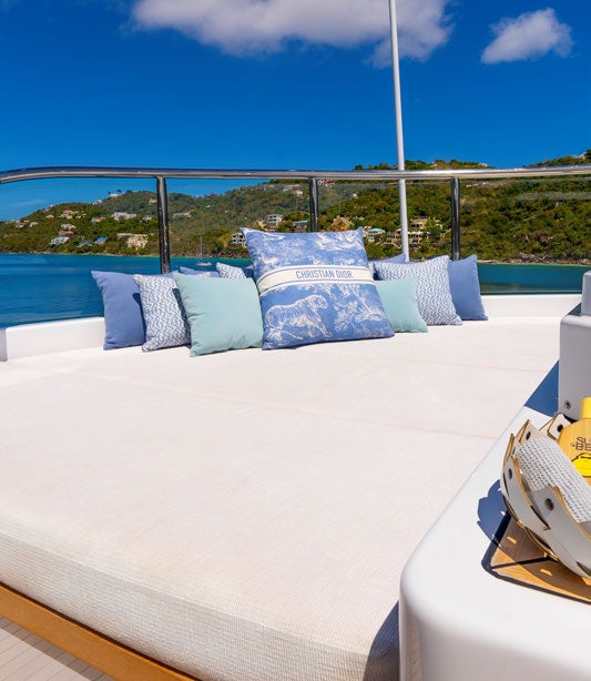 a bed with blue pillows aboard SCOTT FREE Yacht for Charter