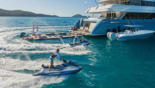 a couple of people on surfboards in the ocean aboard SCOTT FREE Yacht for Charter