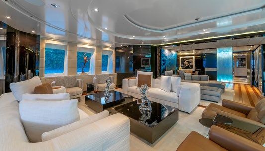 a large living room with white couches and a coffee table aboard SCOTT FREE Yacht for Charter