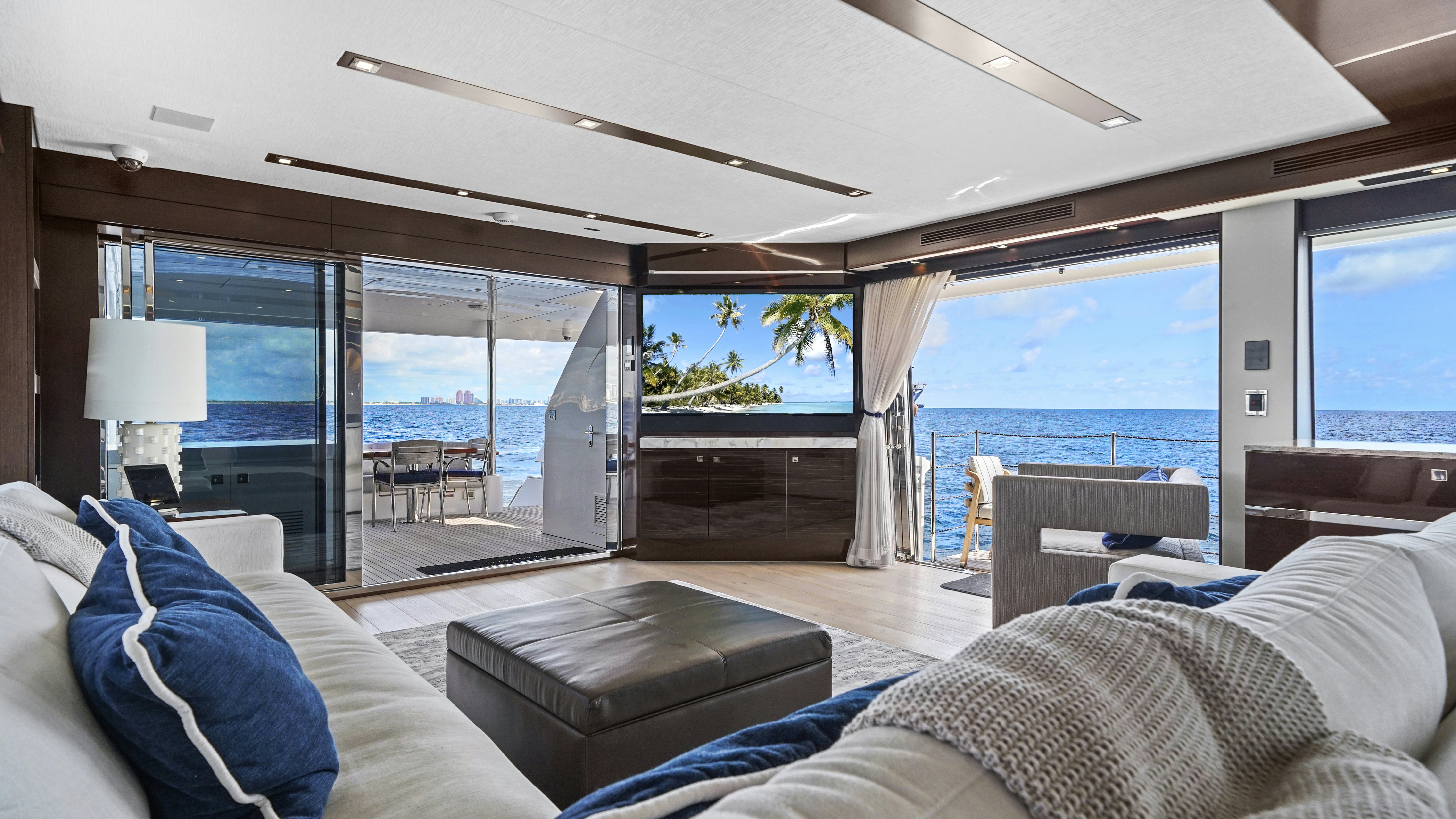 a living room with a large glass door and a view of the ocean aboard SURPLUS LINES Yacht for Sale