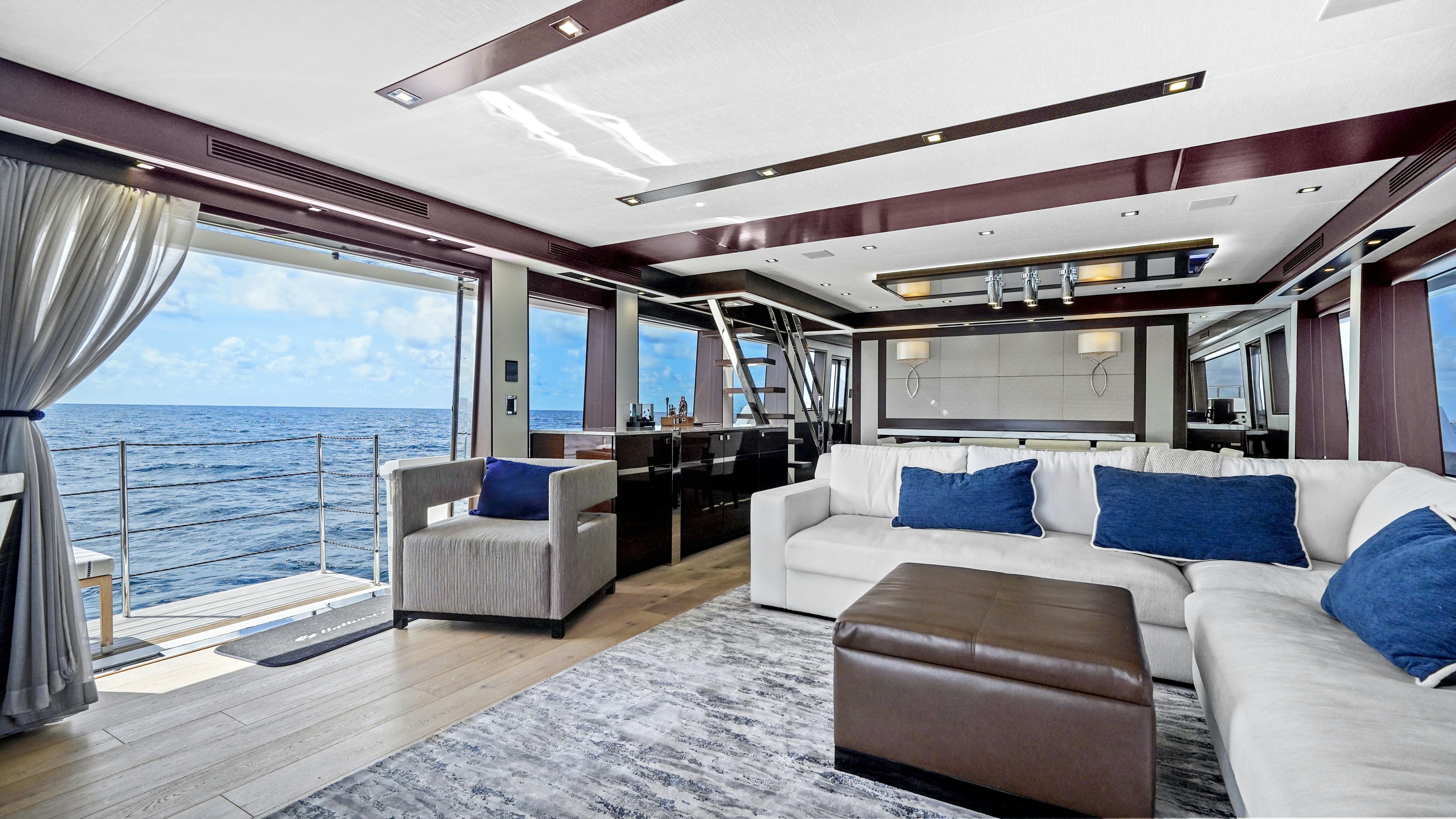 a large living room with a large balcony overlooking the ocean aboard SURPLUS LINES Yacht for Sale