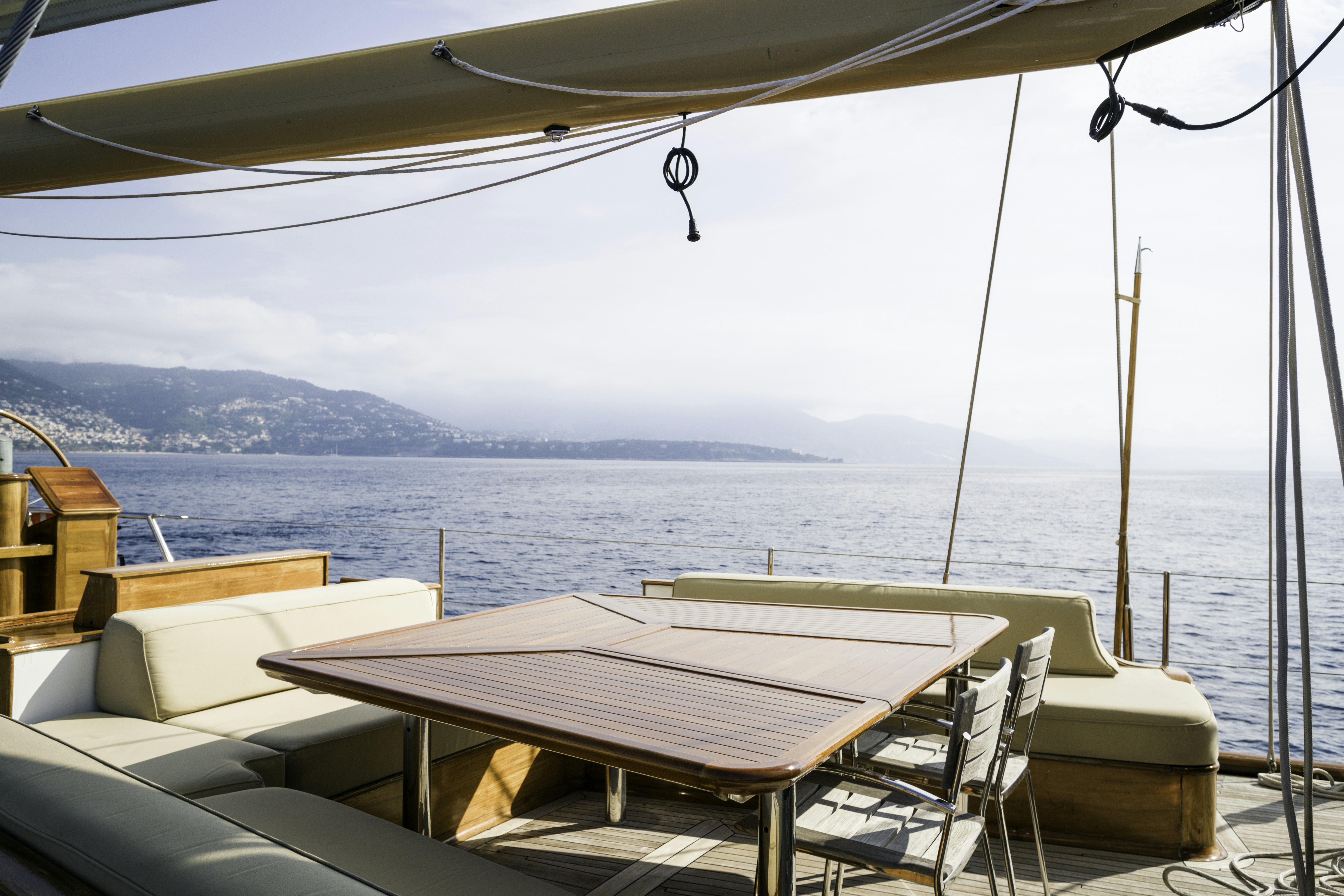 a table and chairs on a deck overlooking a body of water aboard STRANGERS IN THE NIGHT Yacht for Sale