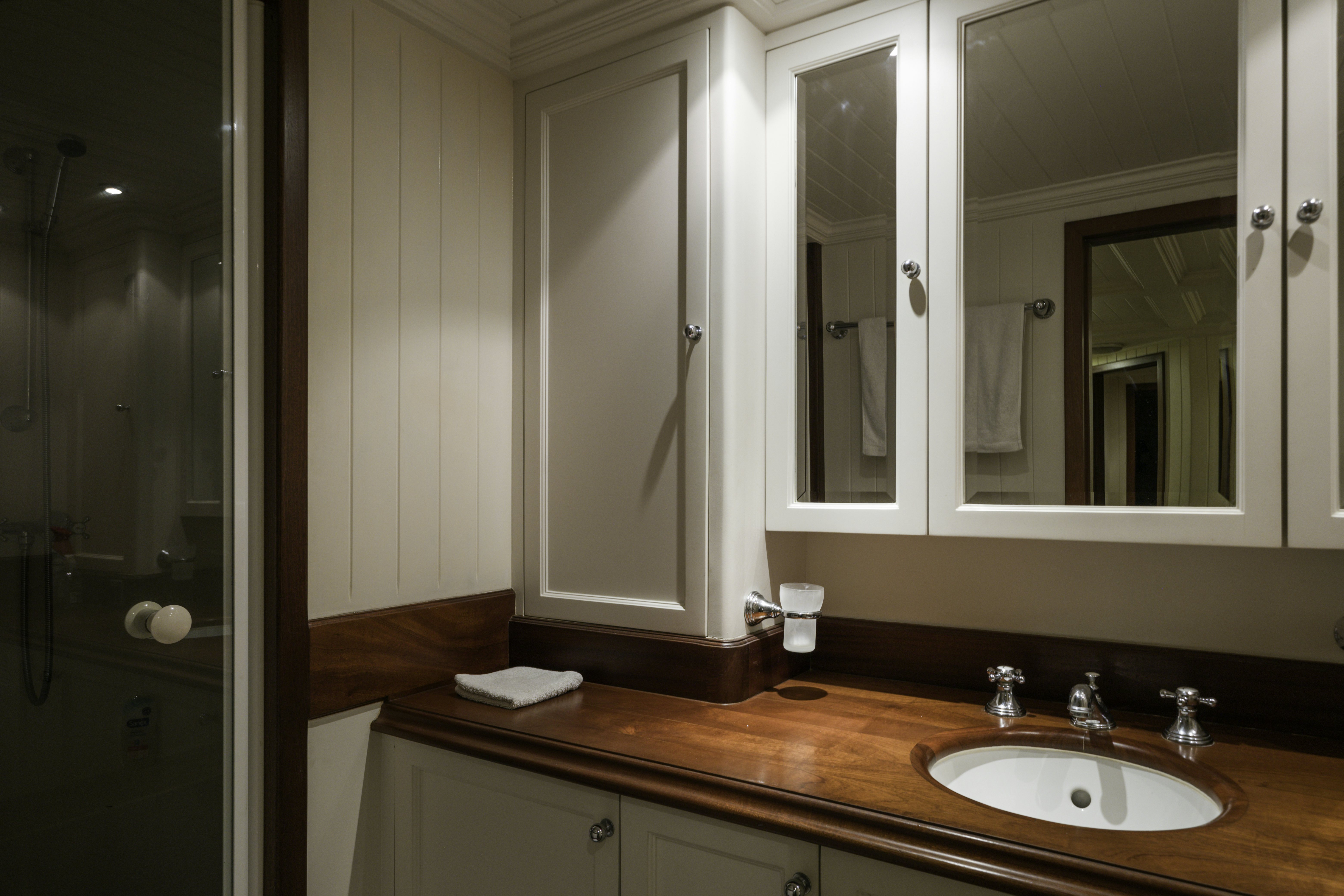 a bathroom with a sink and mirrors aboard STRANGERS IN THE NIGHT Yacht for Sale