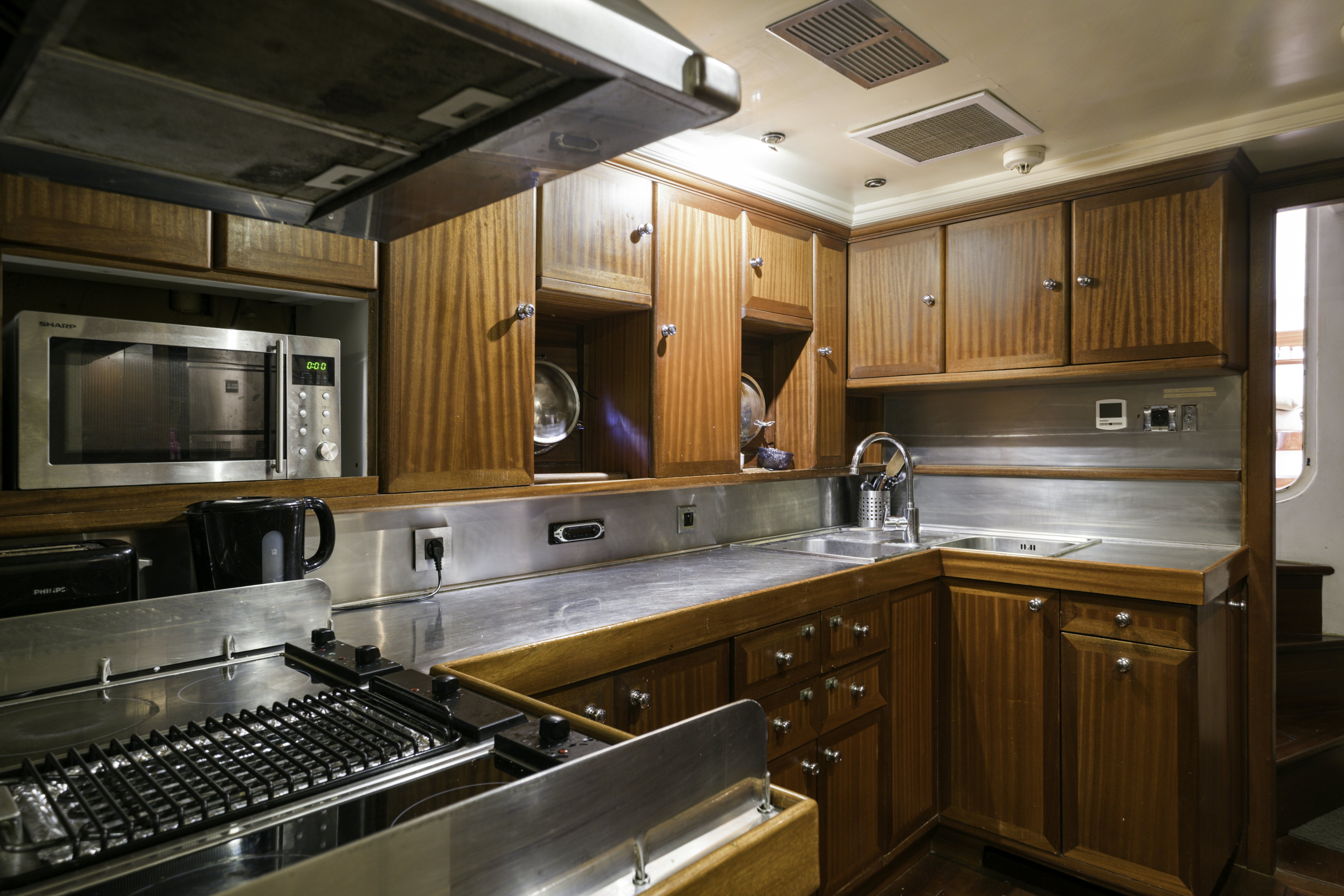 a kitchen with wooden cabinets aboard STRANGERS IN THE NIGHT Yacht for Sale