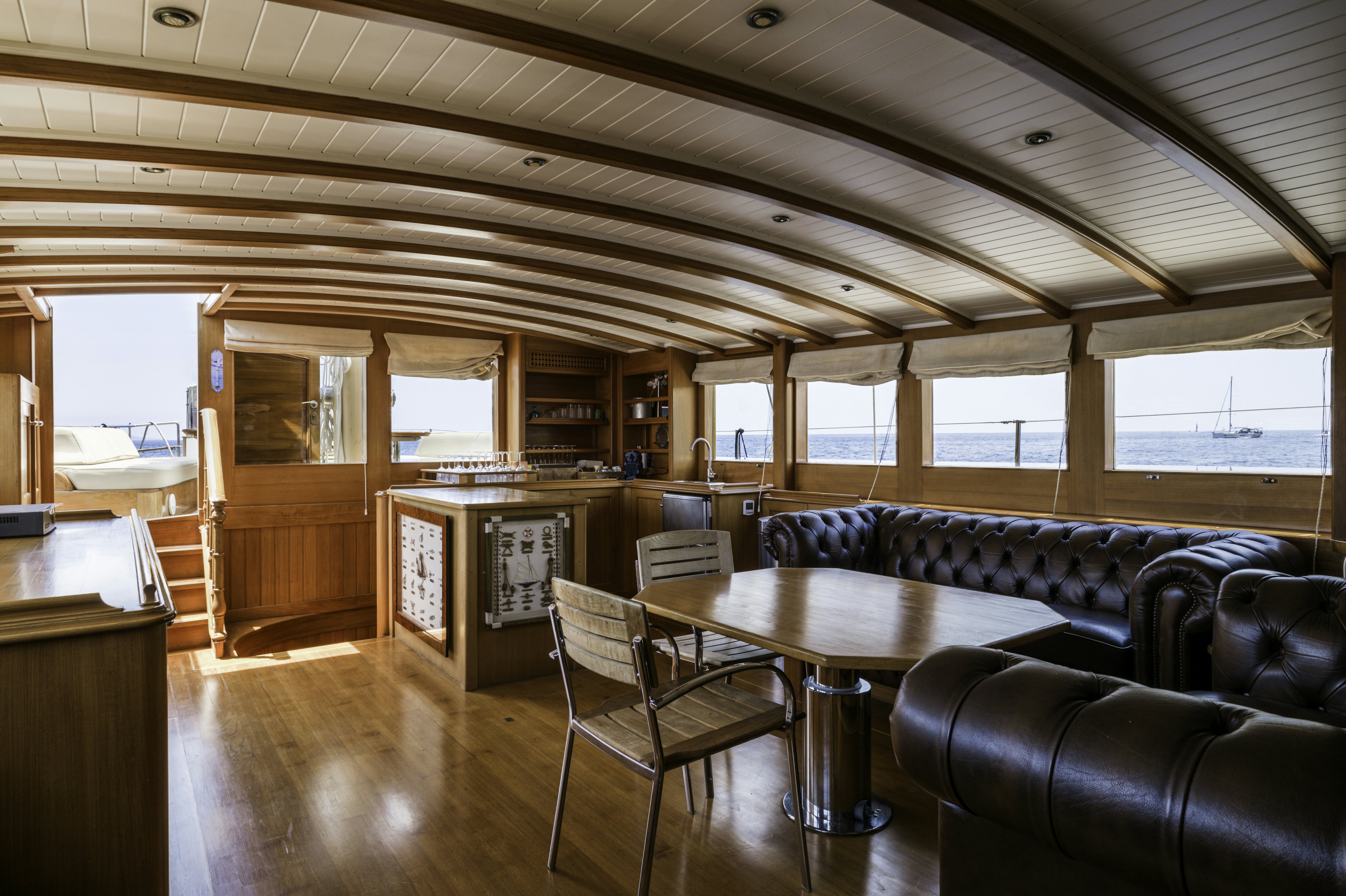 a living room with a couch and a table aboard STRANGERS IN THE NIGHT Yacht for Sale