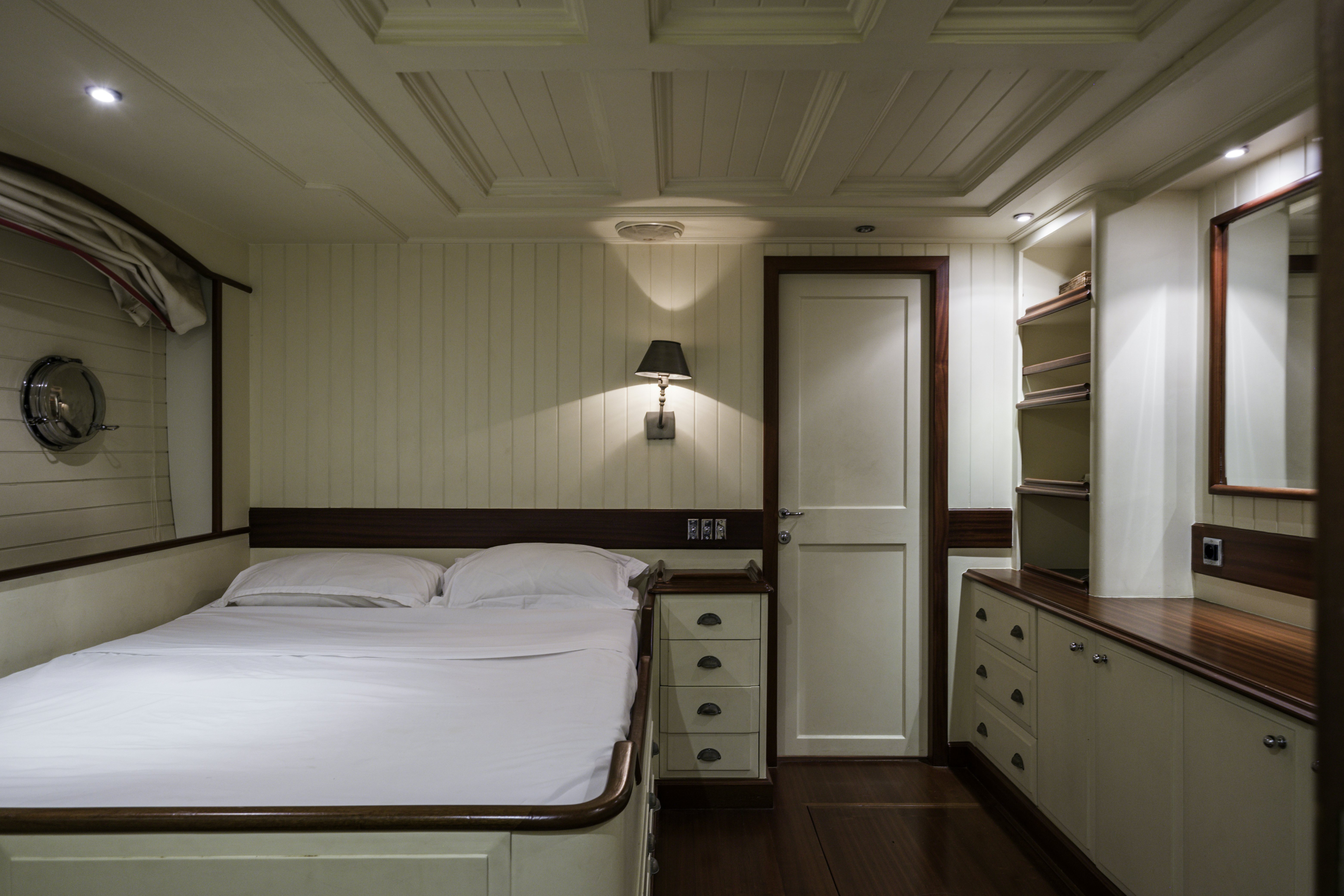 a bedroom with a bed and a mirror aboard STRANGERS IN THE NIGHT Yacht for Sale