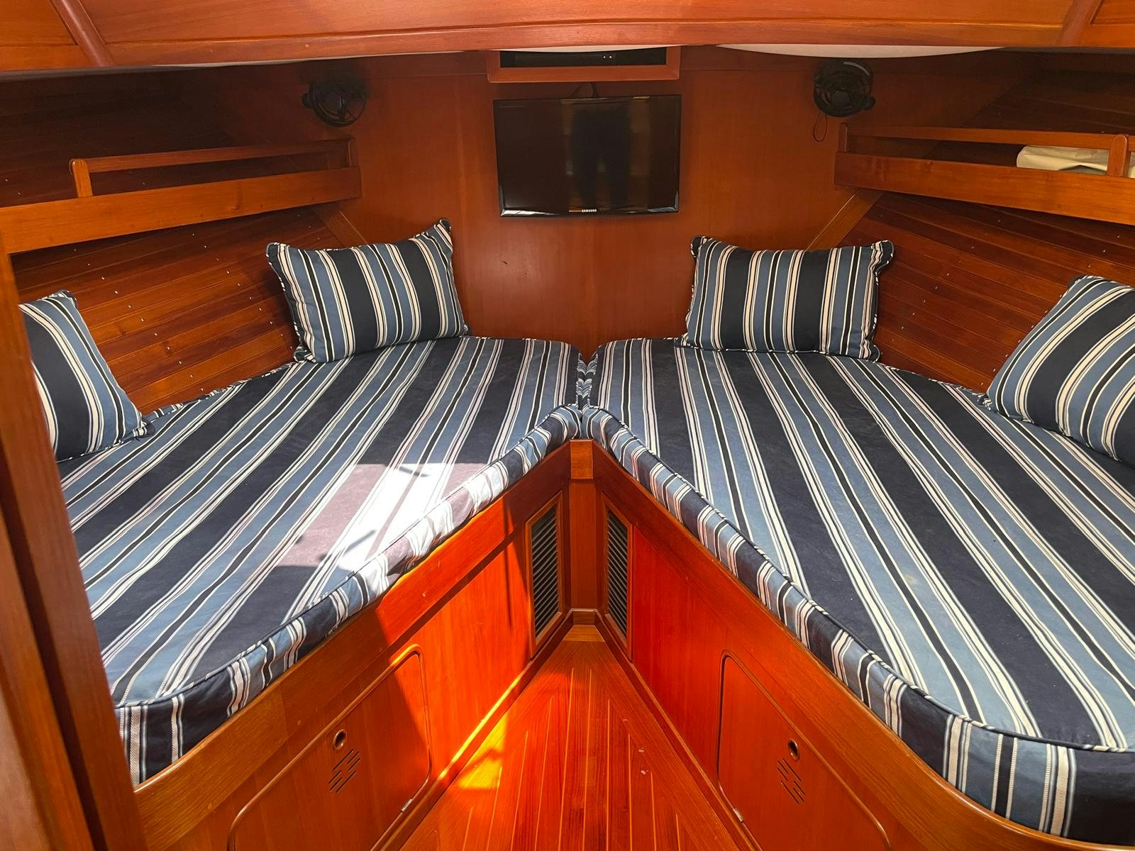 a bed with a striped comforter aboard SOUTHERLY Yacht for Sale