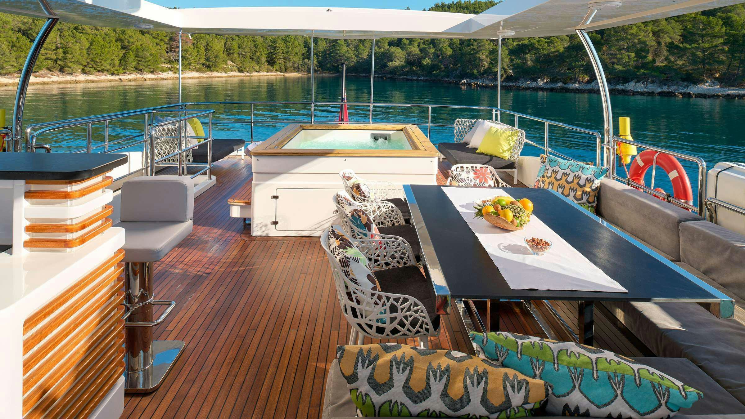 a deck with a table and chairs on it aboard OCEAN DRIVE Yacht for Charter