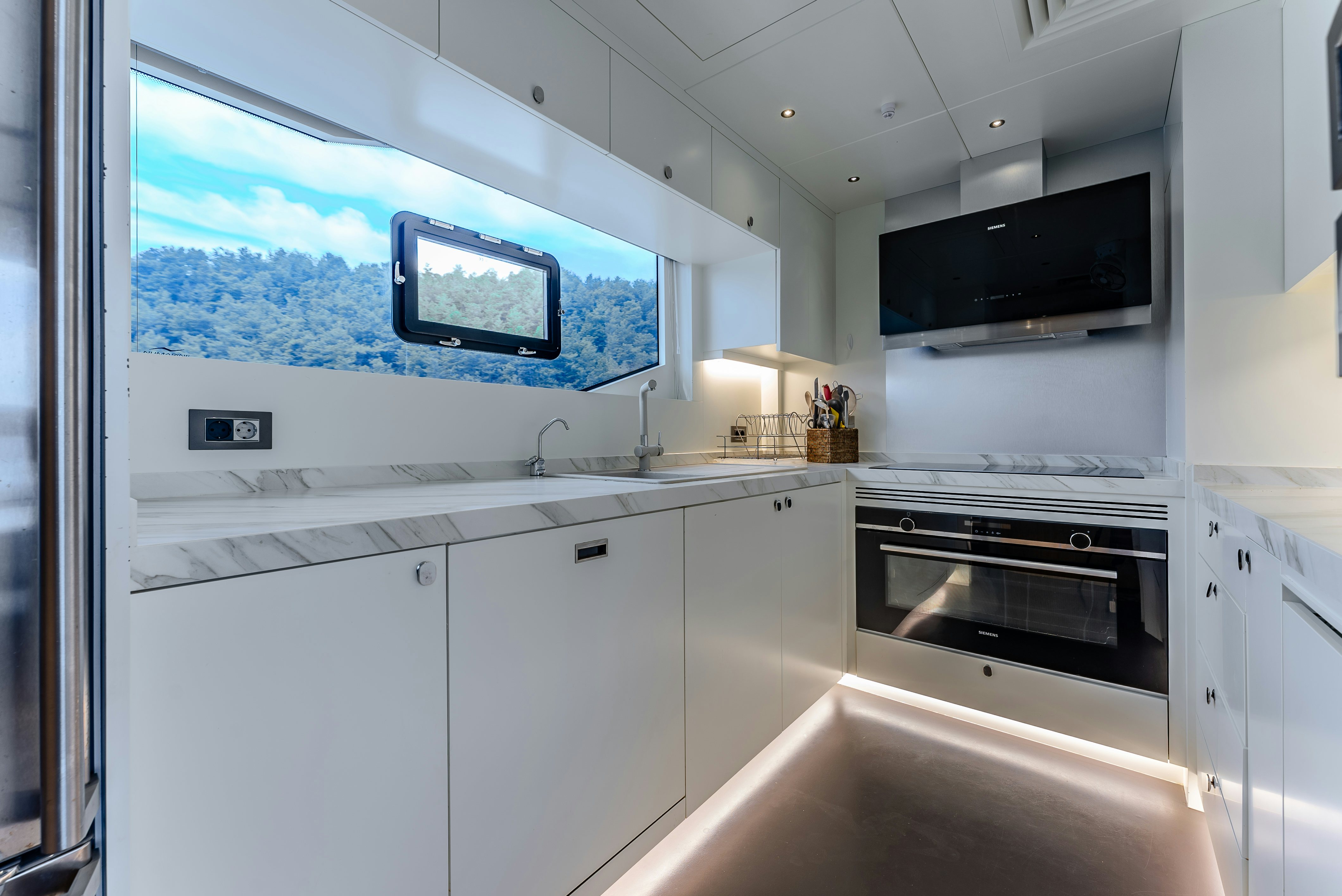 a kitchen with a tv on the wall aboard LITTLE MERMAID Yacht for Sale