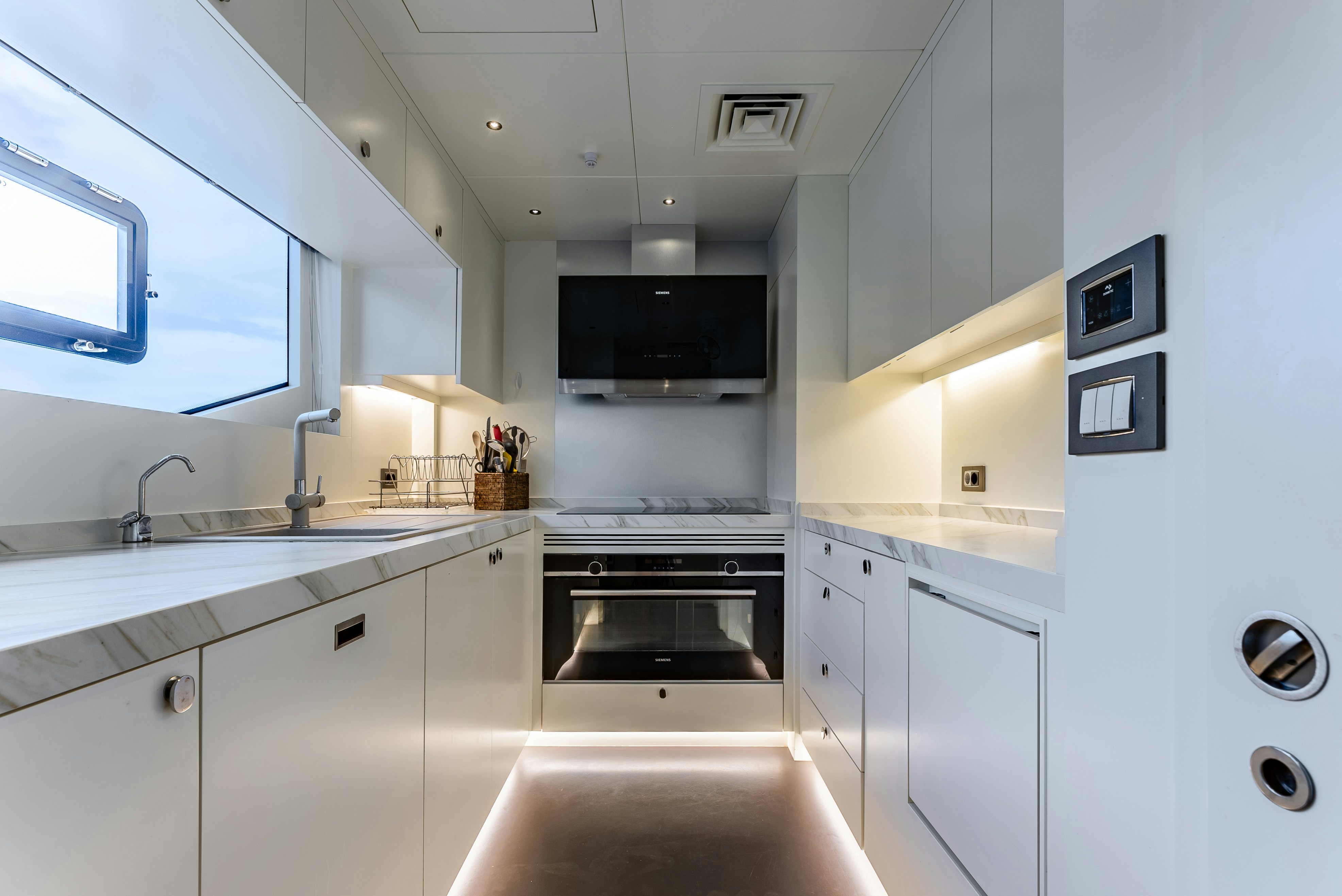 a kitchen with white cabinets aboard LITTLE MERMAID Yacht for Sale