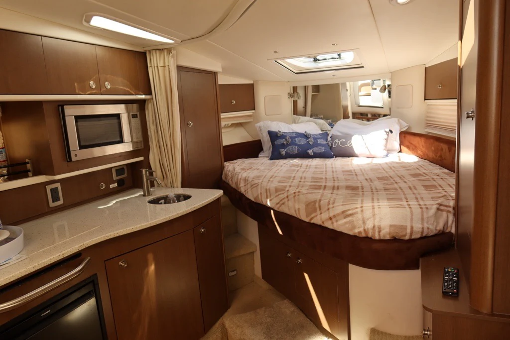 a bedroom with a bed and a microwave aboard BON VOYAGE Yacht for Sale
