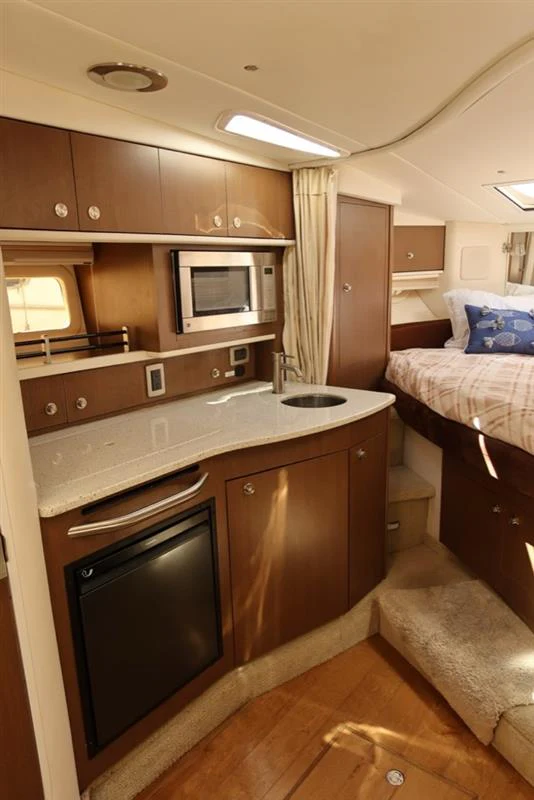 a kitchen with a bed and a microwave aboard BON VOYAGE Yacht for Sale