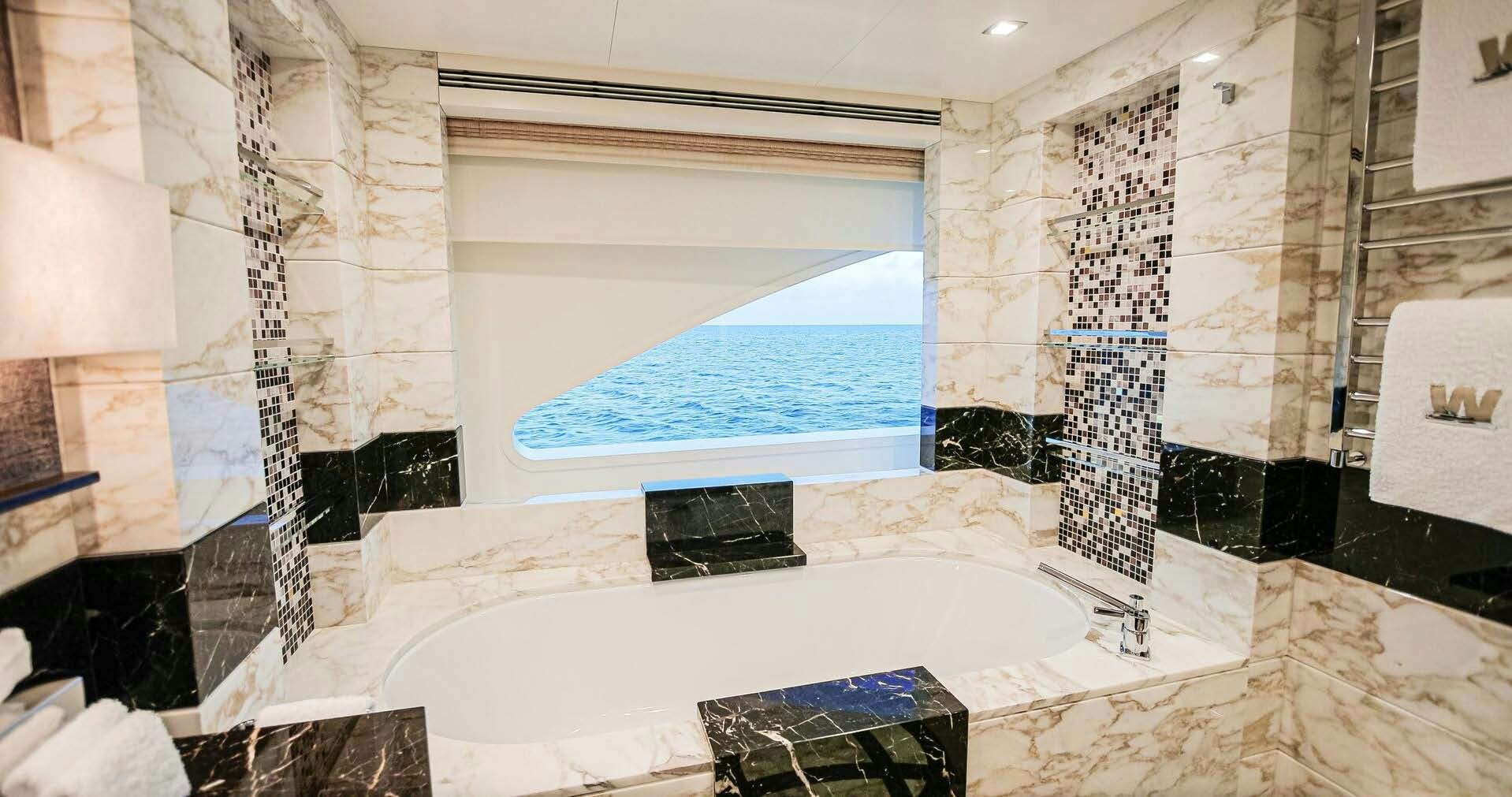 a bathroom with a tub and a sink aboard W Yacht for Charter