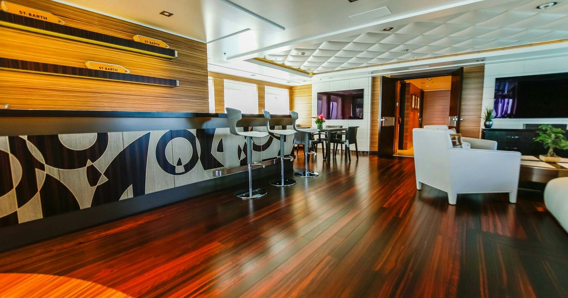 a room with a wood floor and white couches aboard W Yacht for Charter