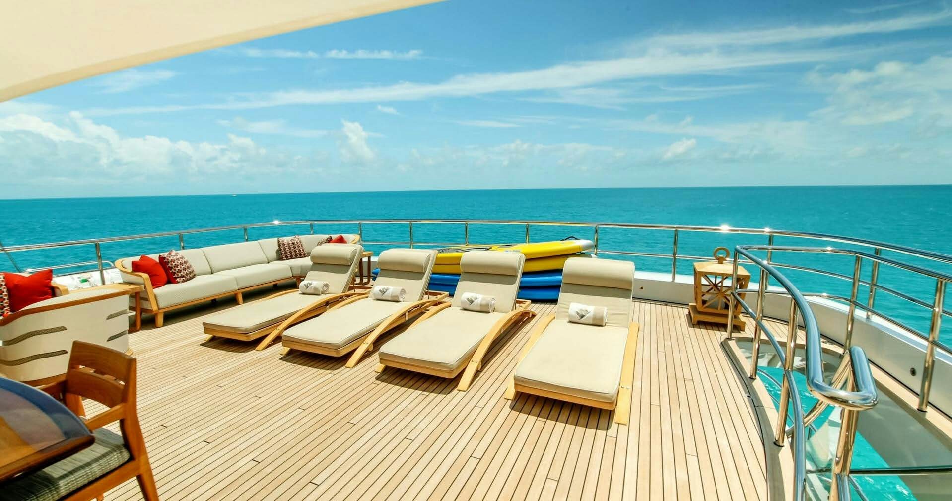 a large lounge area with a large body of water in the background aboard W Yacht for Charter