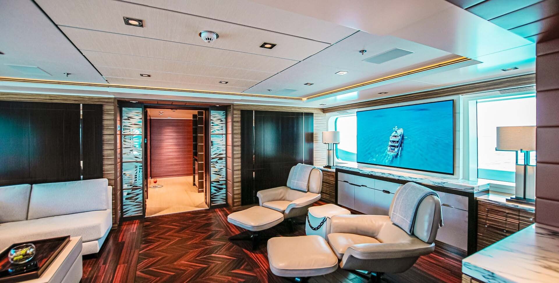 a living room with a large screen aboard W Yacht for Charter