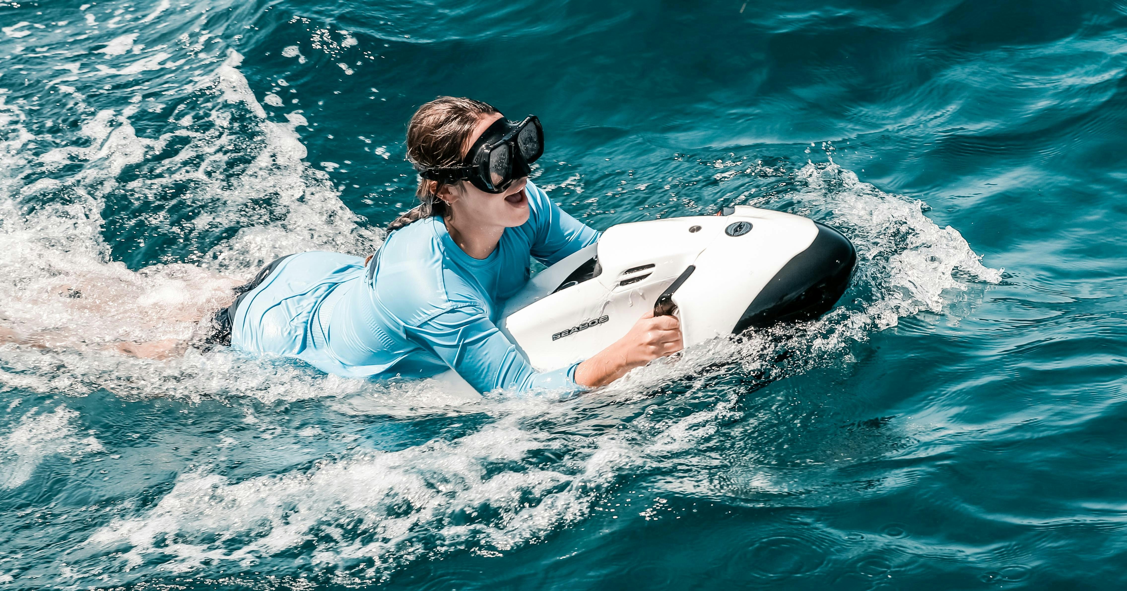 a person in a white suit on a white surfboard in the ocean aboard MIRABELLA Yacht for Charter