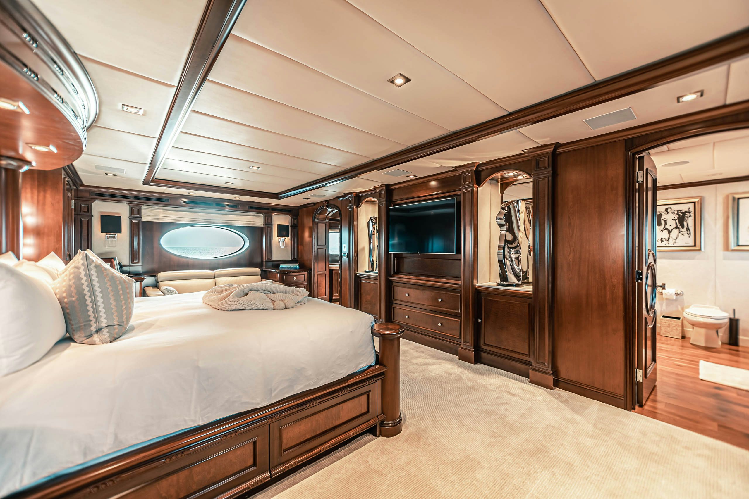 a bedroom with a bed and a wood cabinet aboard MIRABELLA Yacht for Charter
