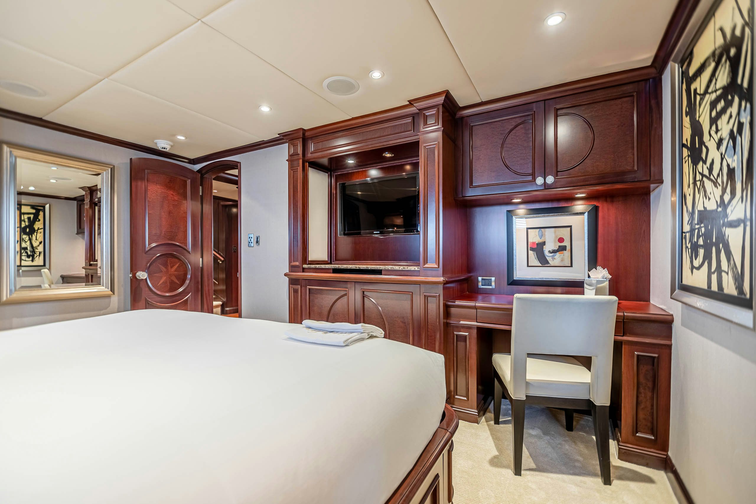 a bedroom with a bed and desk aboard MIRABELLA Yacht for Charter