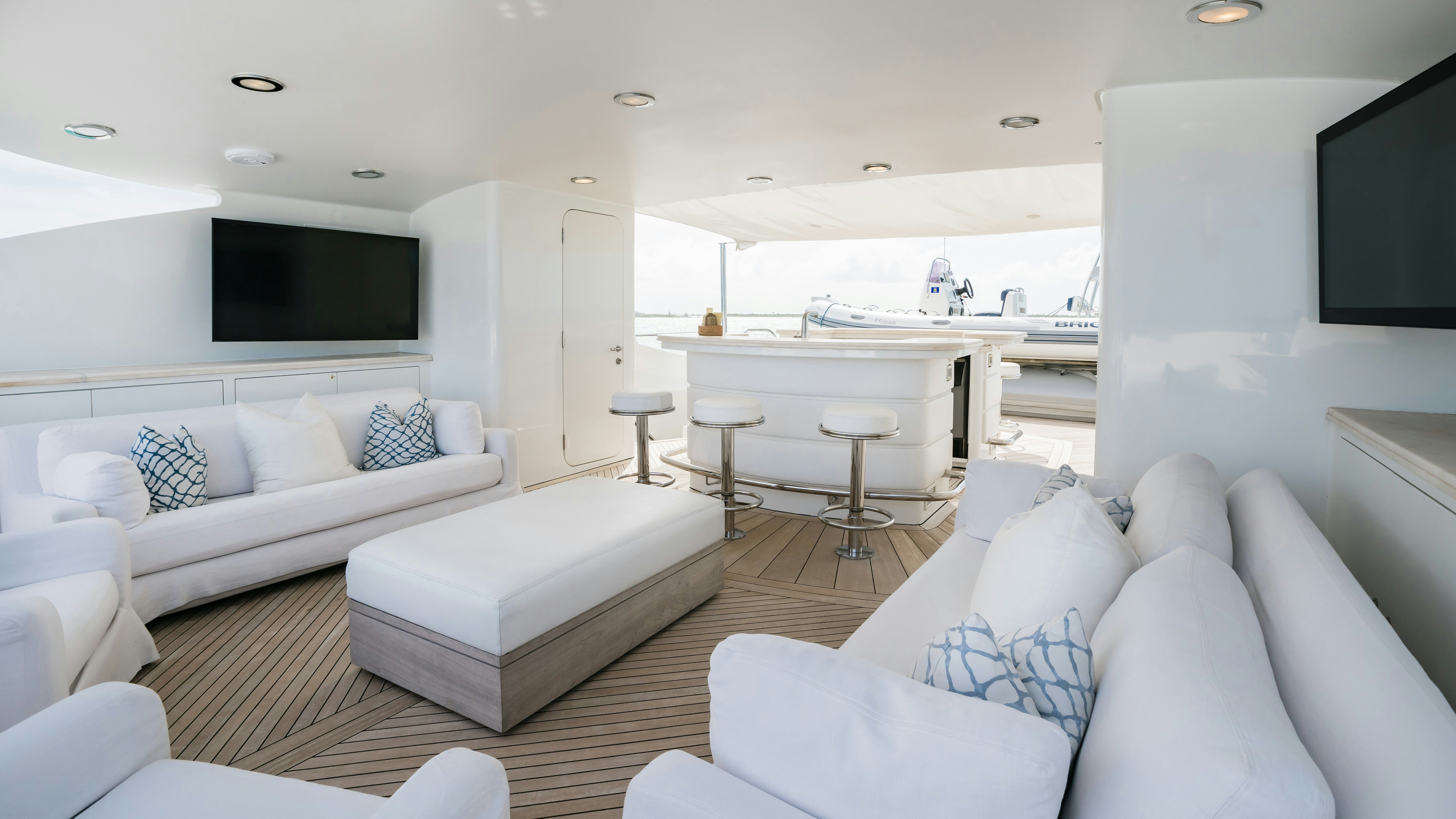 a living room with a large white sofa and a large tv aboard MIRABELLA Yacht for Sale