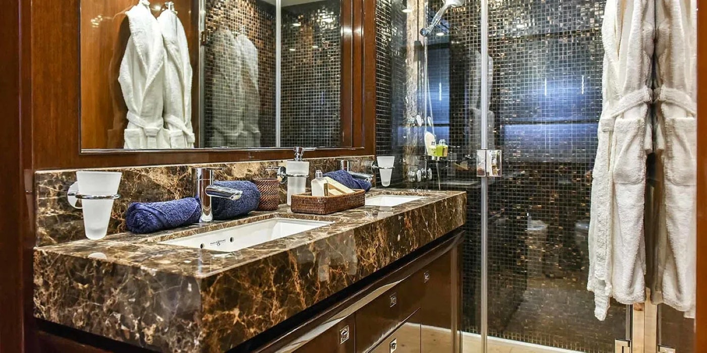 a bathroom with a countertop sink and a large mirror aboard AGAVE Yacht for Sale