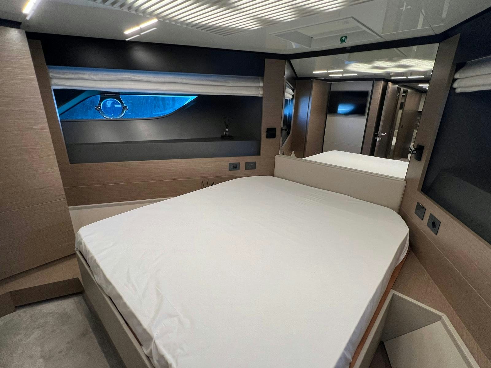 a room with a bed and a mirror aboard PICCOLINO Yacht for Sale