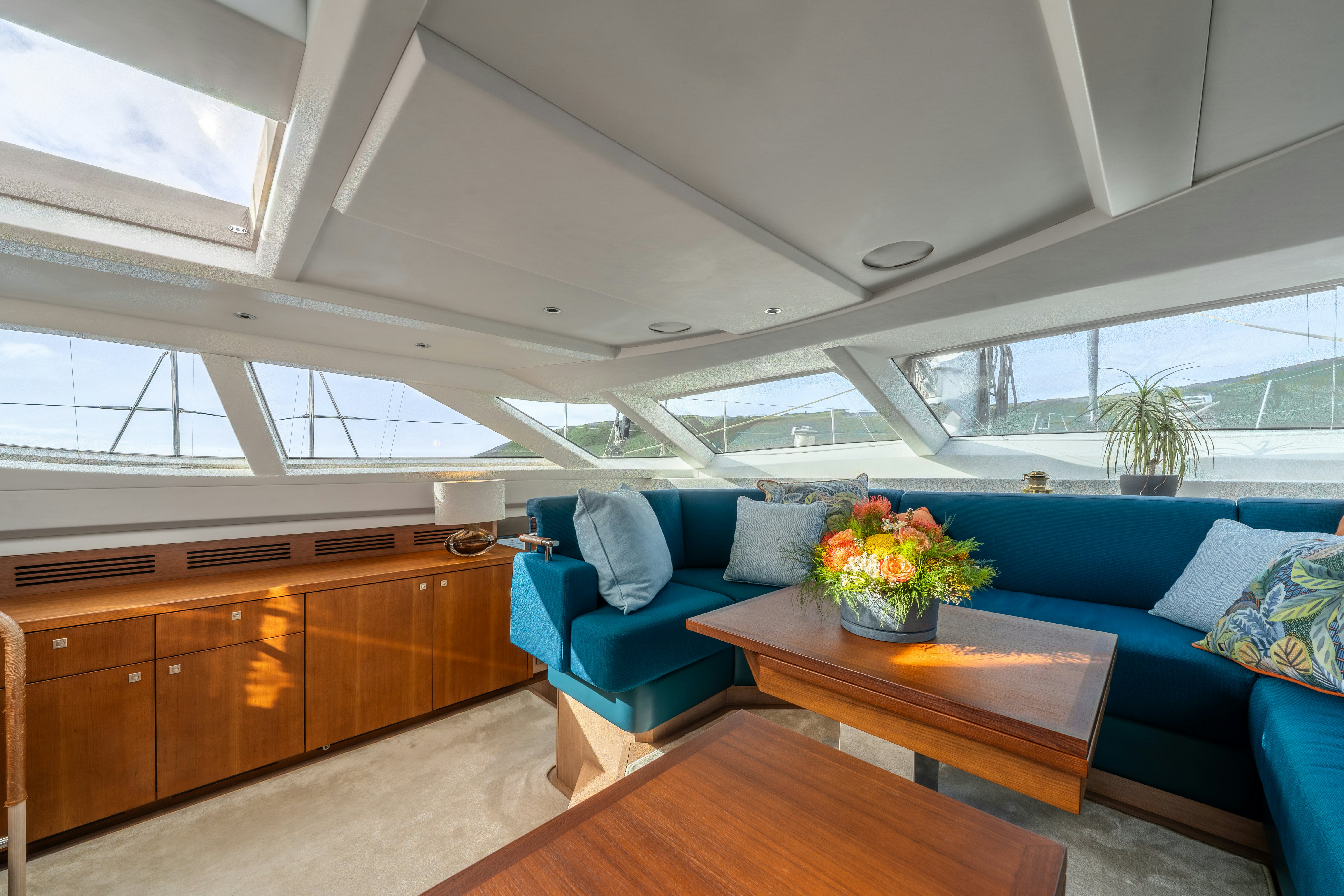 a living room with a blue couch aboard KARIBU Yacht for Sale