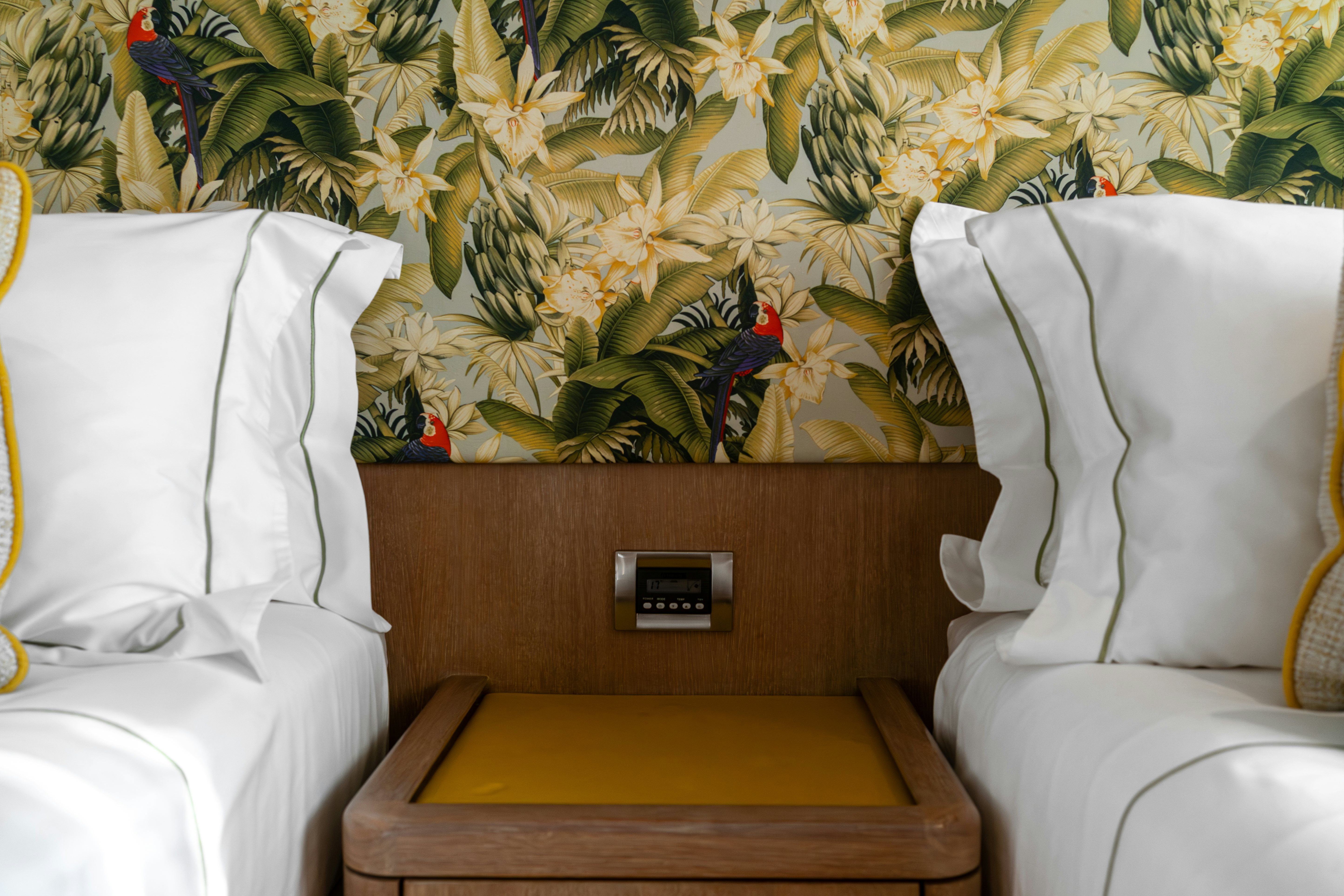 a bed with a pillow and a table with a yellow tray aboard KARIBU Yacht for Sale