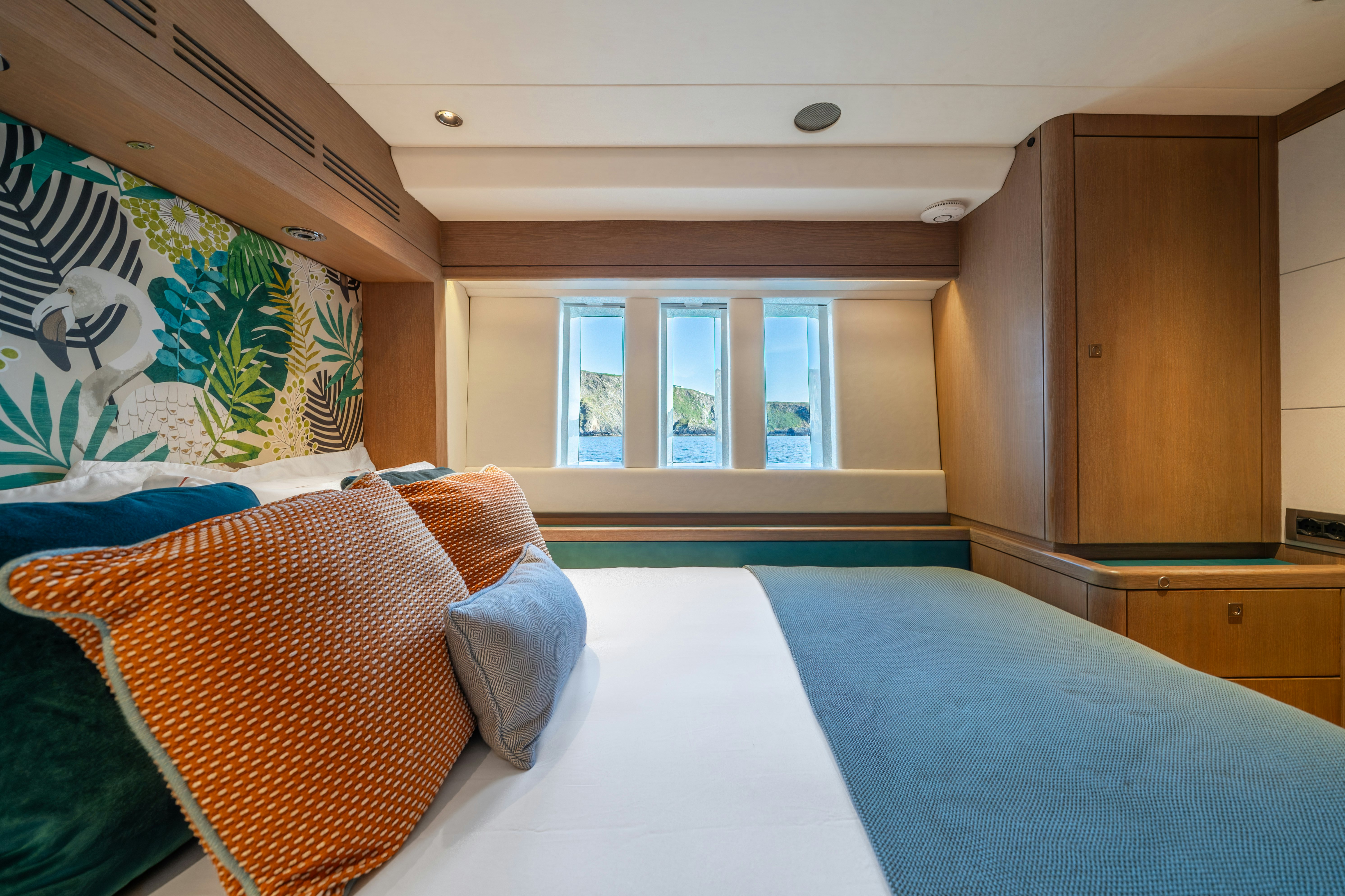 a bedroom with a blue bed spread aboard KARIBU Yacht for Sale