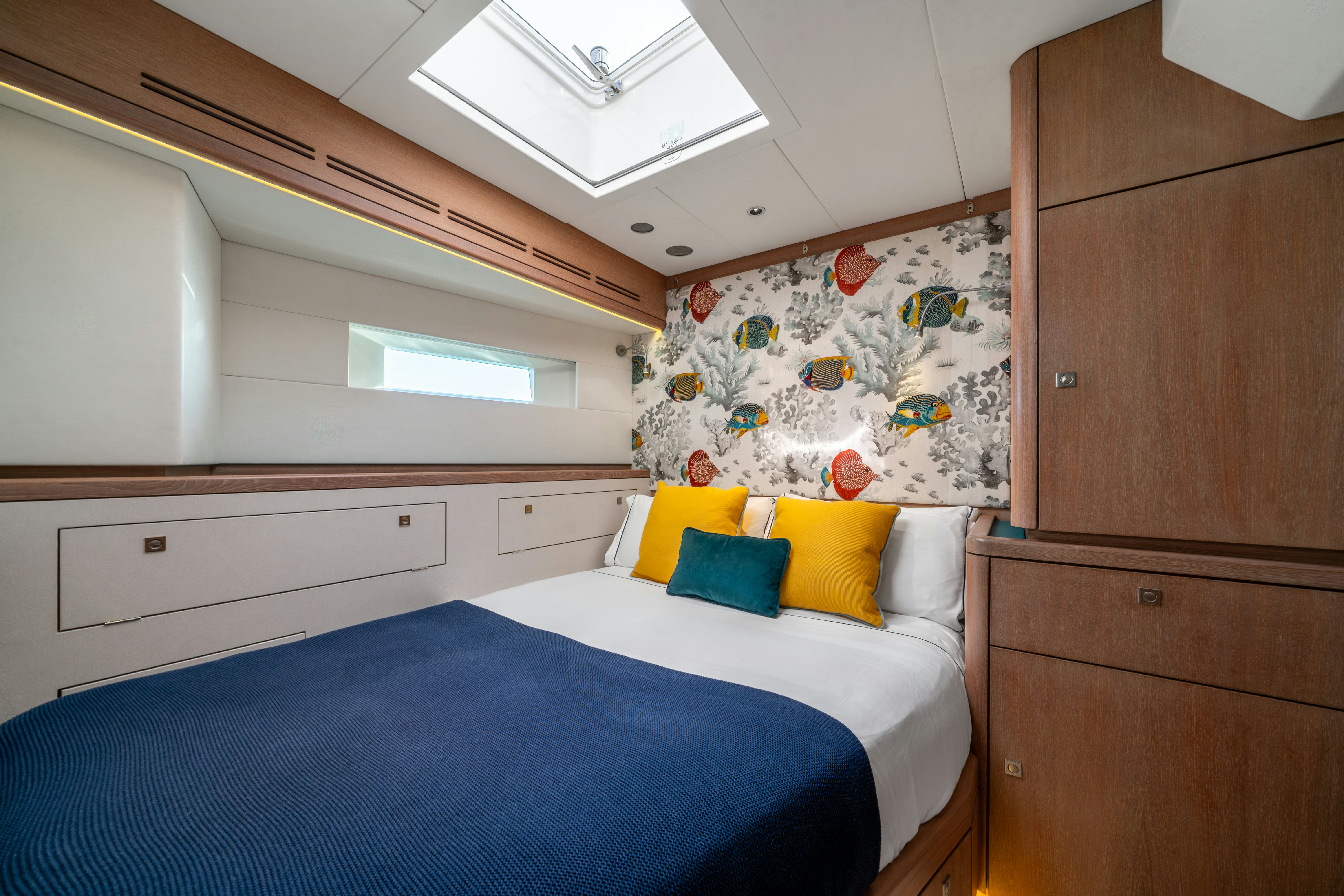 a bedroom with a bed and a dresser aboard KARIBU Yacht for Sale