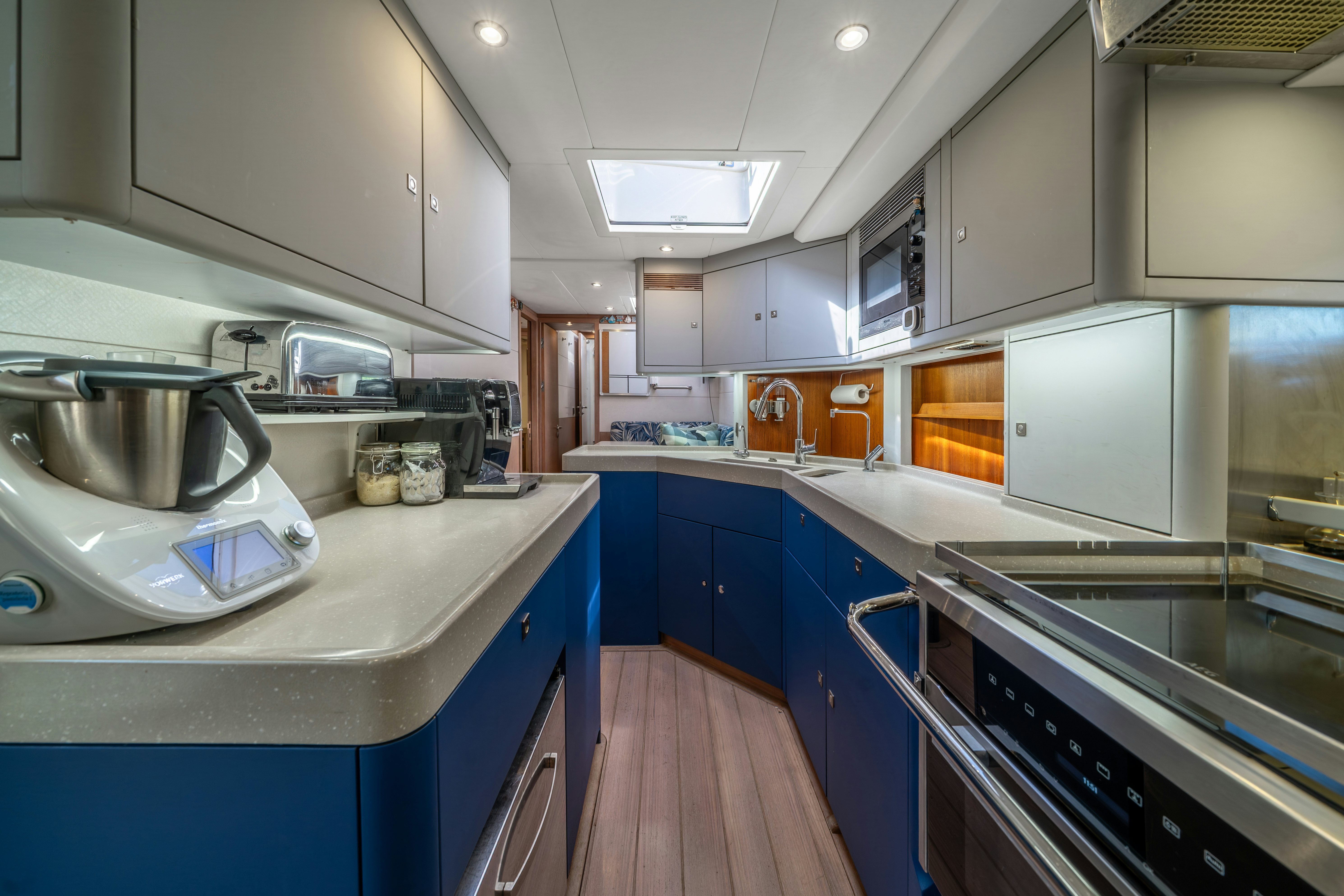a kitchen with blue cabinets aboard KARIBU Yacht for Sale