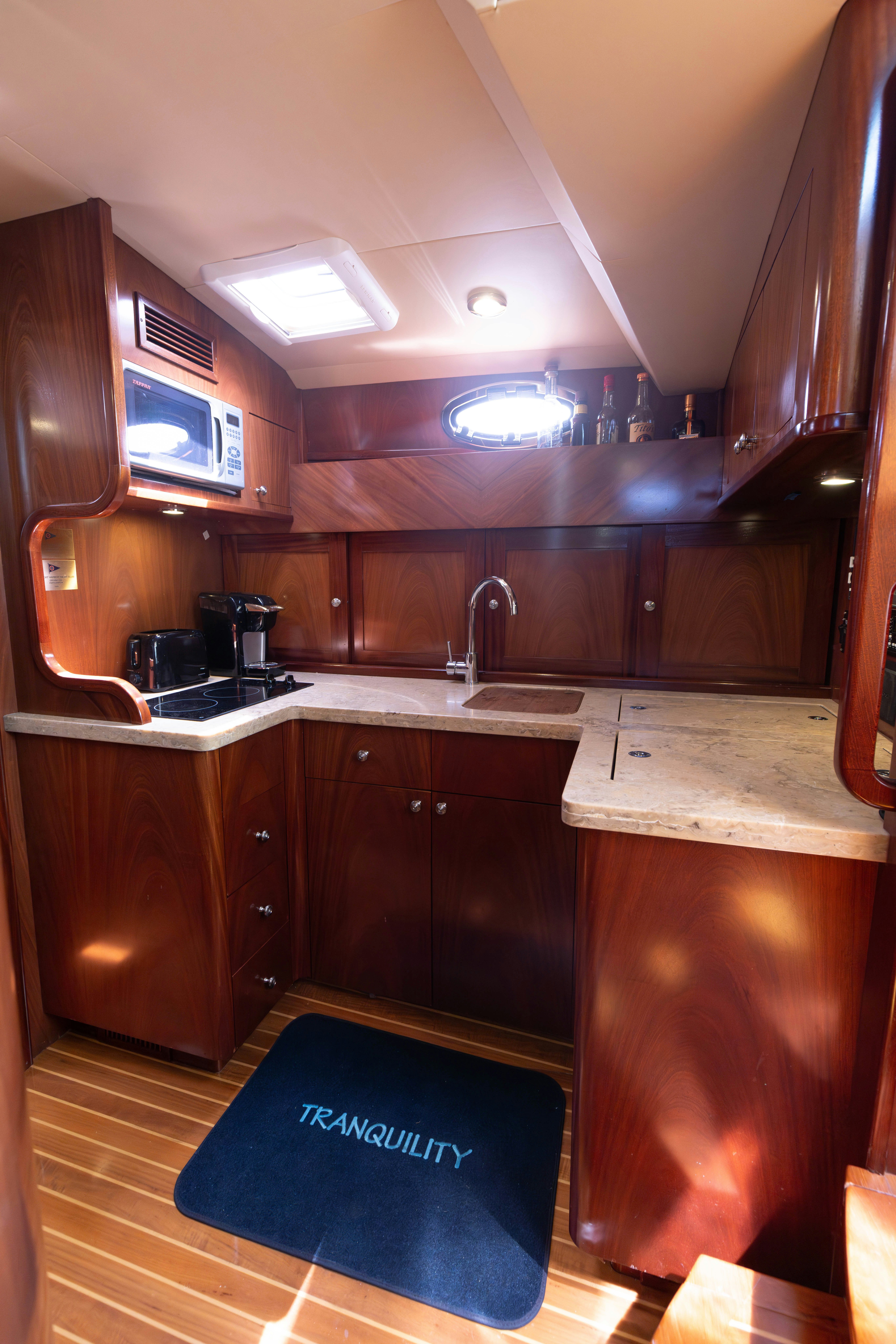 a kitchen with wooden cabinets aboard TRANQUILITY Yacht for Sale